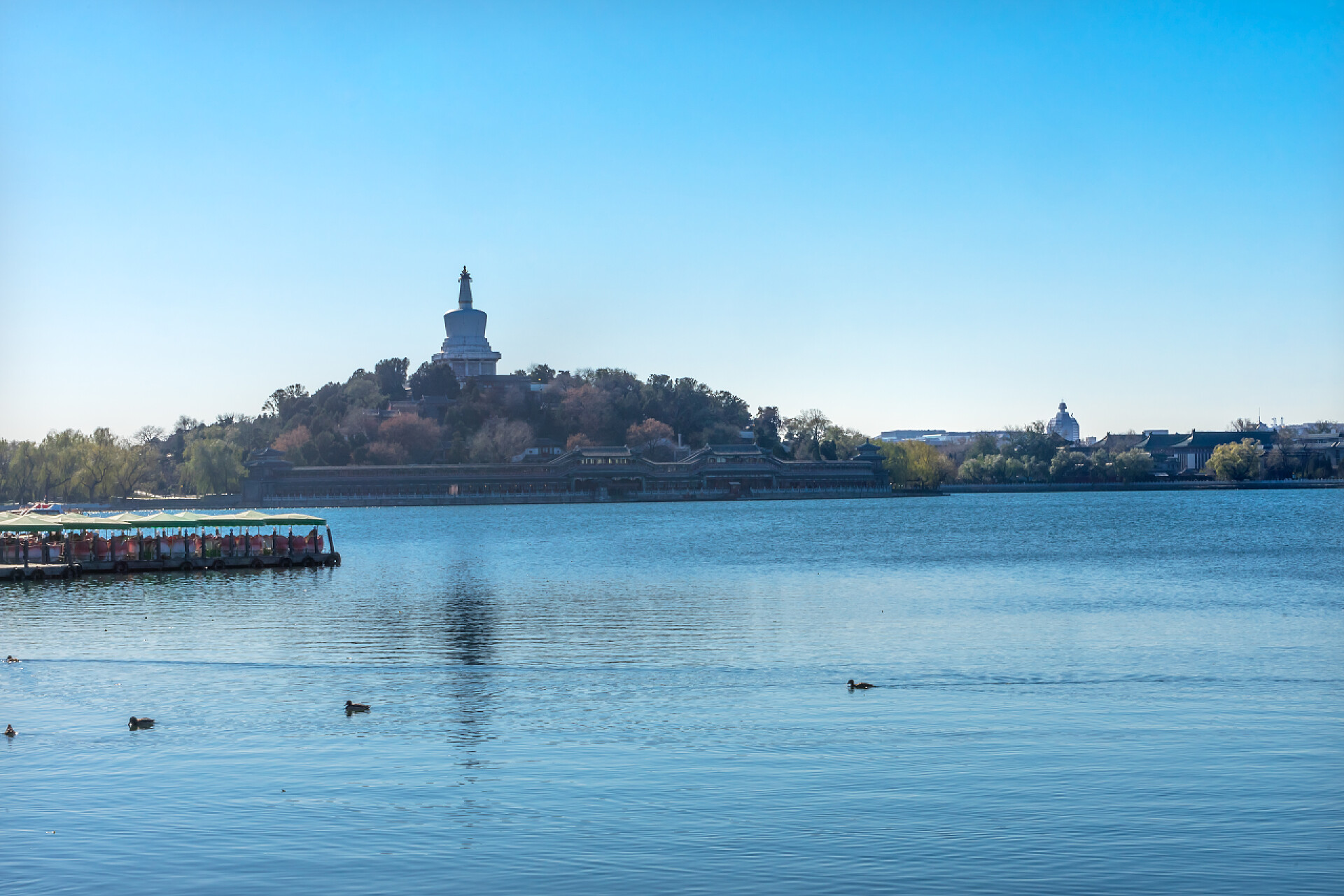 蓝天白云下美丽的北海公园佛教佛塔小船北海湖公园玉花岛北京中国北海公园是一个公共公园, 创建于1000ad。.