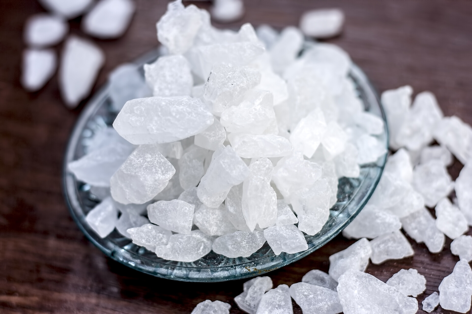 红褐色木桌上放着冰糖块木质玻璃板材中的冰糖或糖立方.