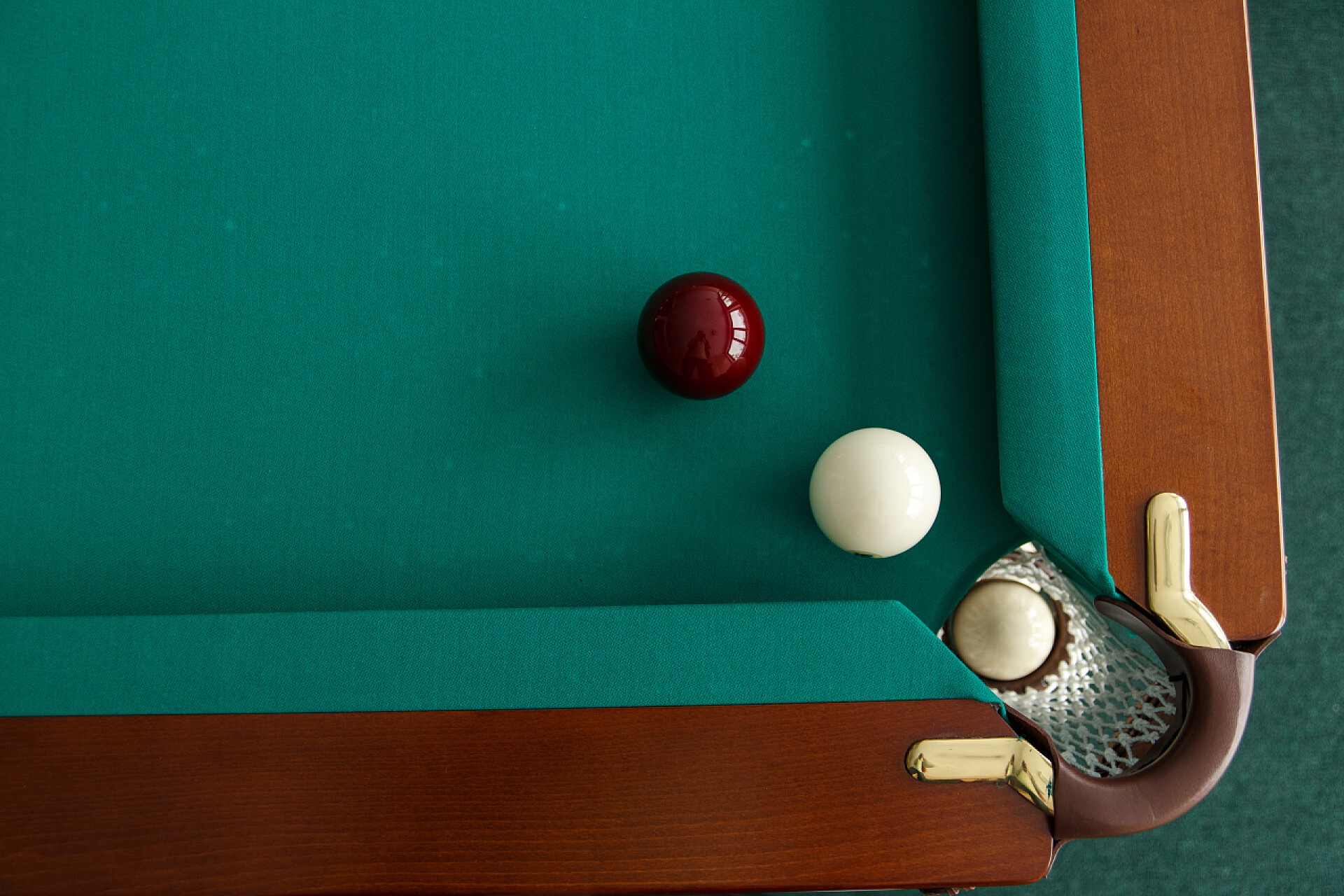 俯拍台球进洞台球桌。顶部视图。球滚进口袋。Greencloth