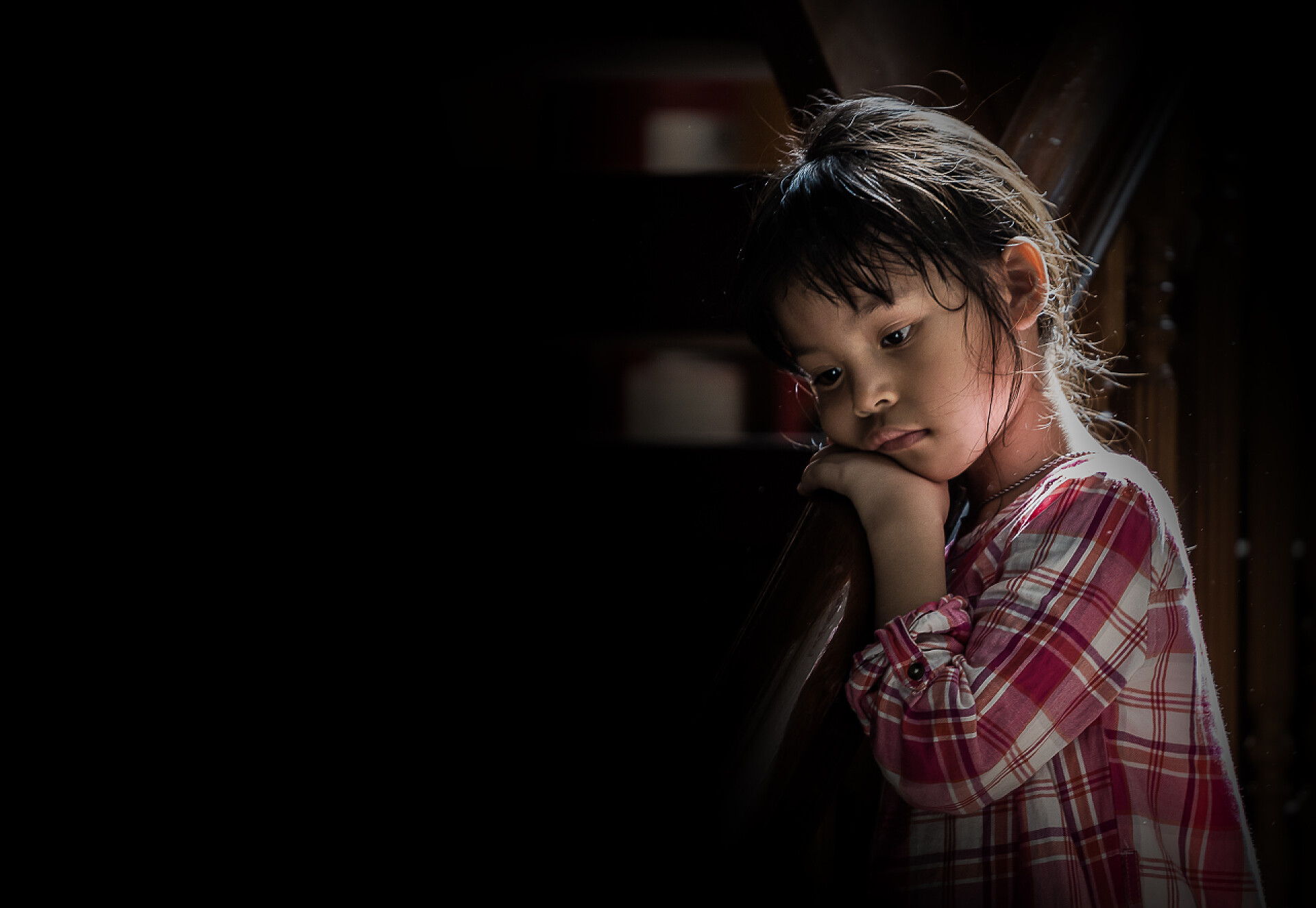 黑色背景上一个悲伤的小女孩亚洲女孩是哀伤的