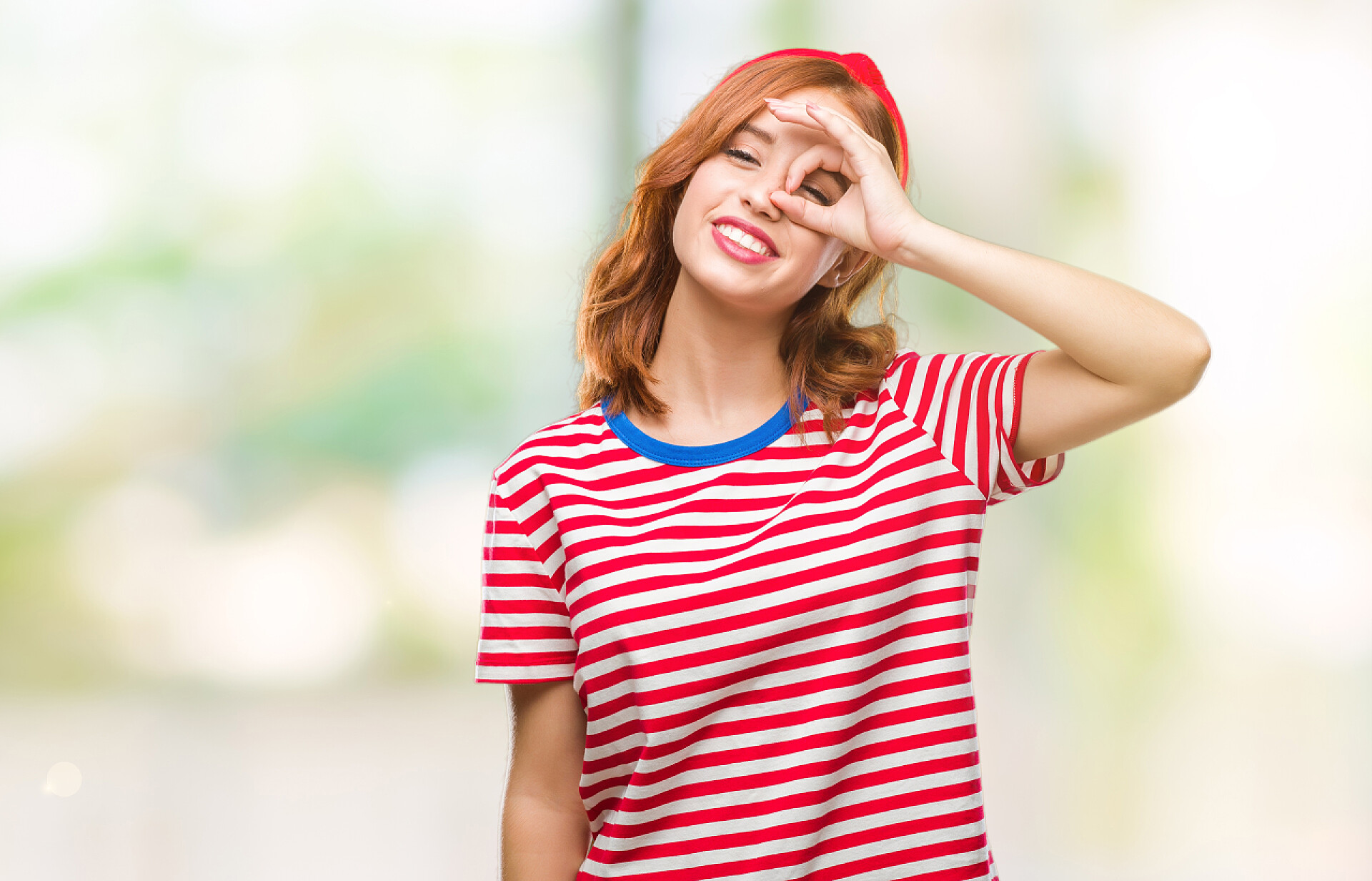 年轻女人做OK手势年轻美丽的女人在孤立的背景下做 ok 手势用手微笑, 眼睛看通过手指与愉快的面孔.