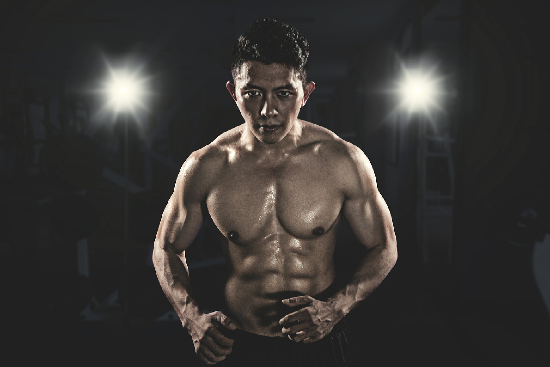 黑暗中的肌肉男图为肌肉发达的亚洲男子站在黑暗的房间里看着镜头