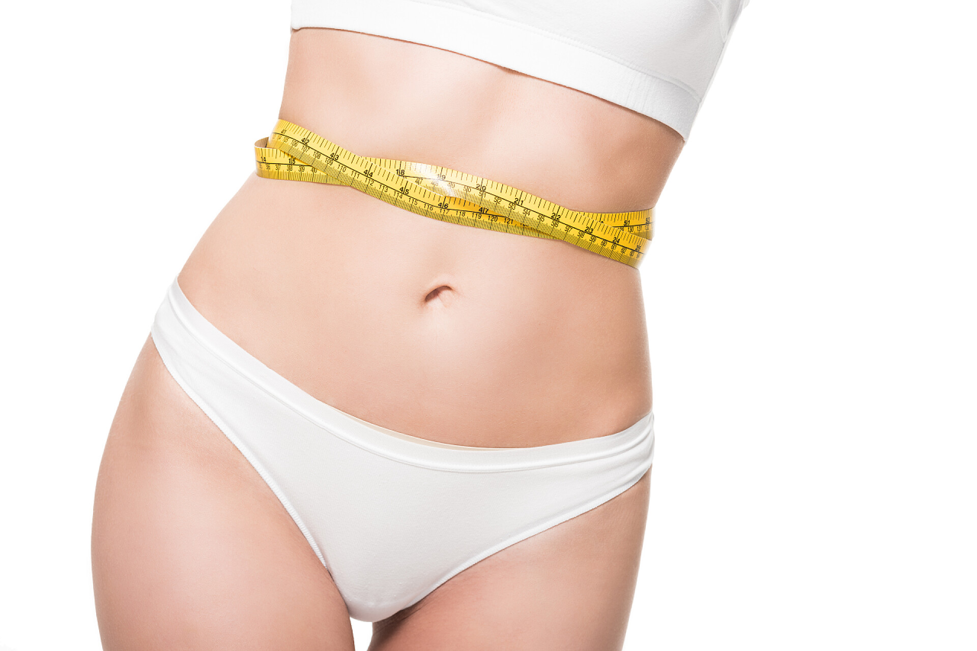 美丽苗条的女孩腰部缠着尺子特写中段年轻女子在内衣与测量胶带在腰部隔离在白色