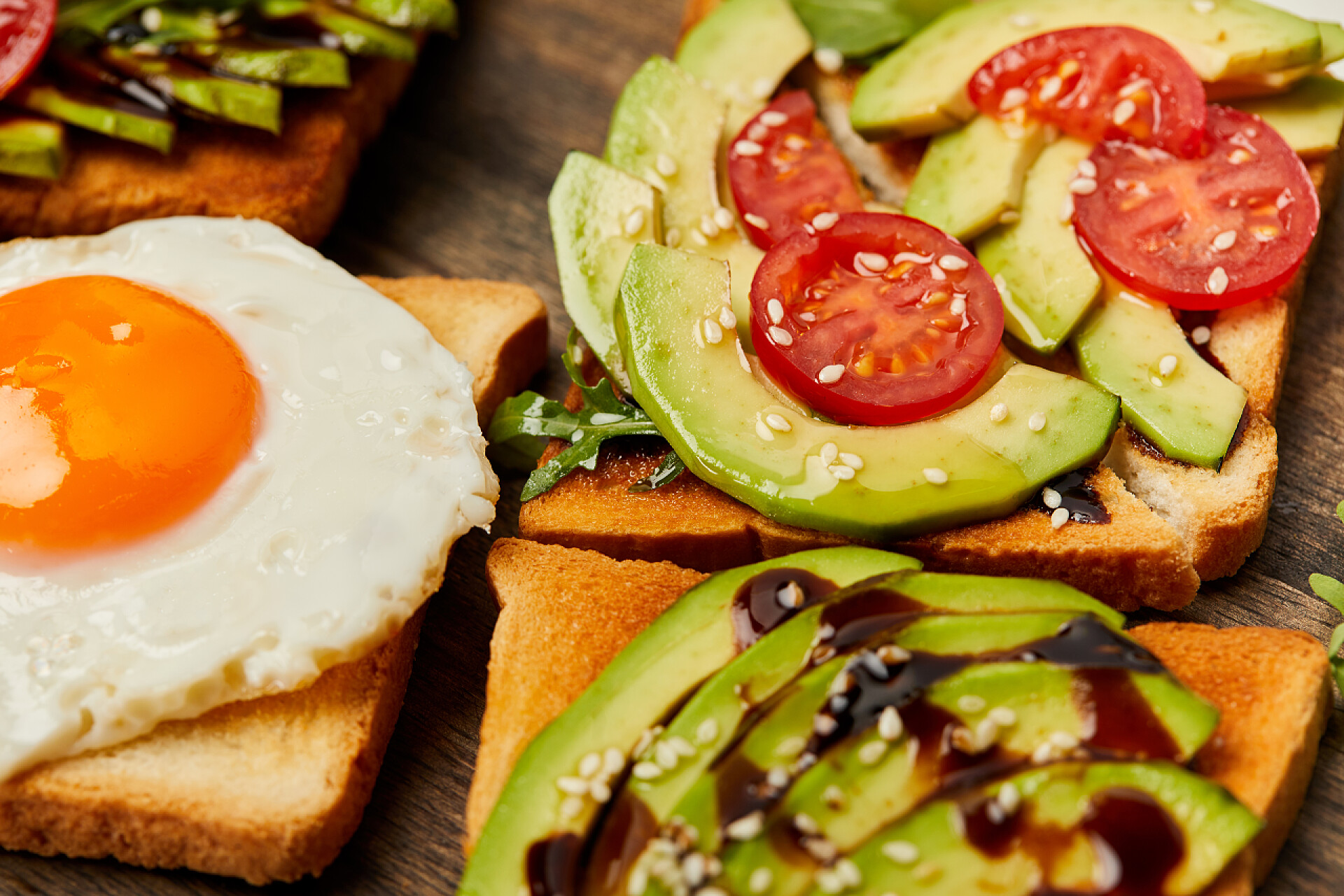 桌子上摆满了水果蔬菜和煎蛋有选择的焦点与炒鸡蛋, 樱桃西红柿和鳄梨在木背景上