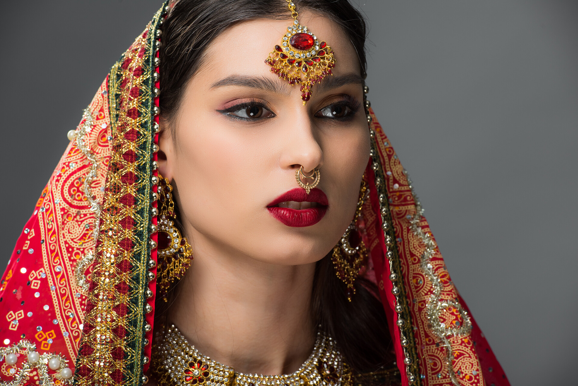 灰色背景一个头戴纱丽的美丽印度女人有吸引力的印度妇女摆在传统的纱丽和宾迪, 隔离在灰色 