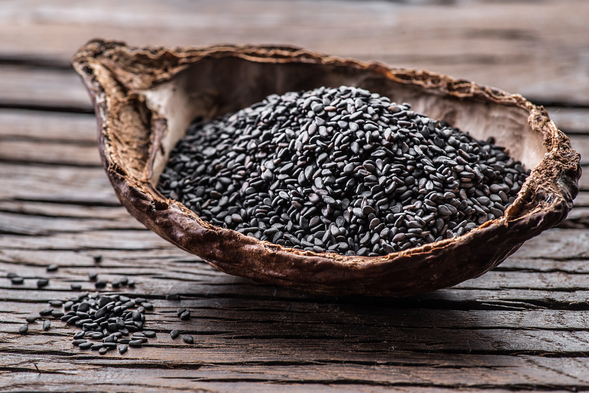 桌子上的一碗黑芝麻黑芝麻在旧木桌上的有机碗里。返回页首 