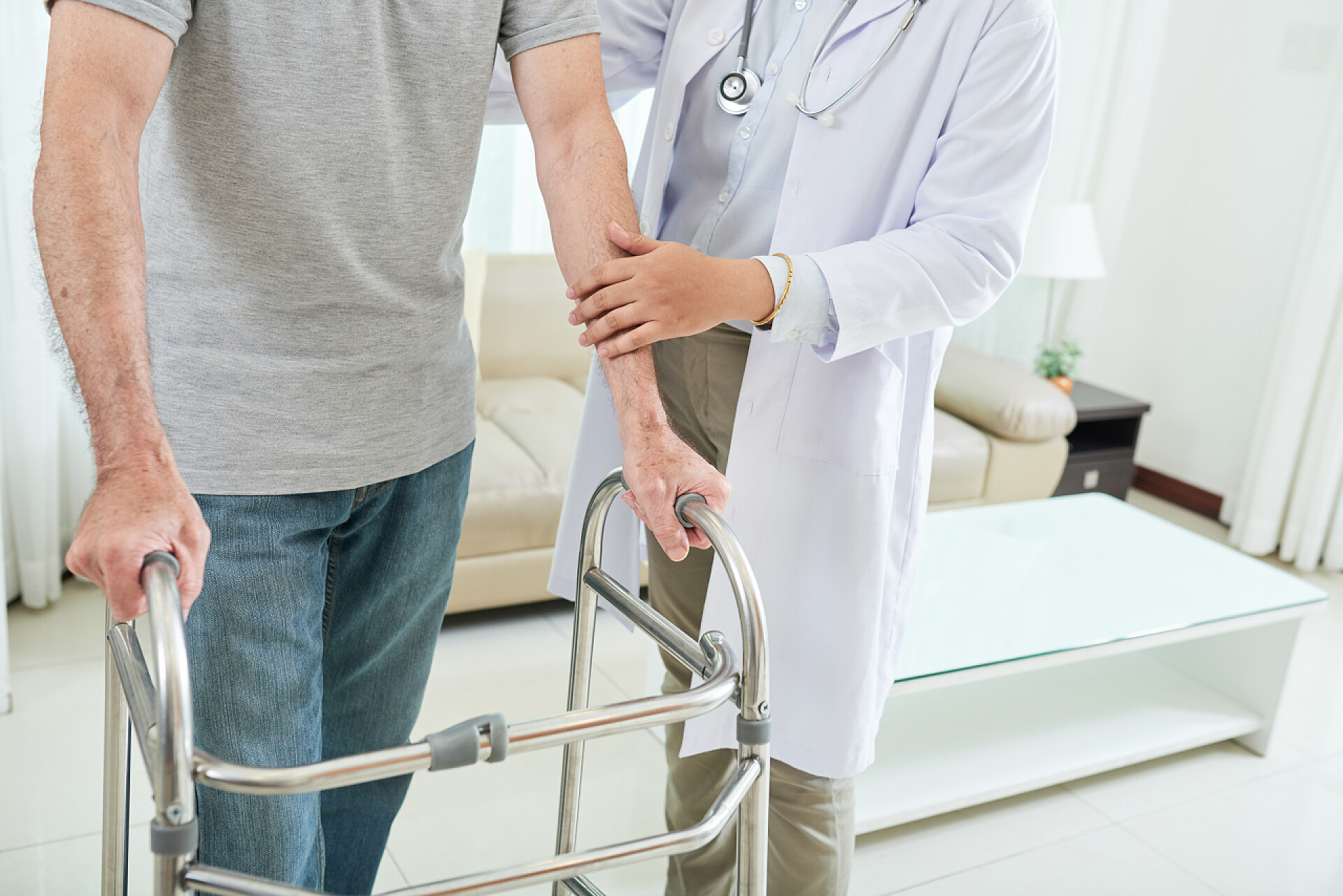 医生帮助患者康复用步行者在医生的帮助下, 在家里散步 