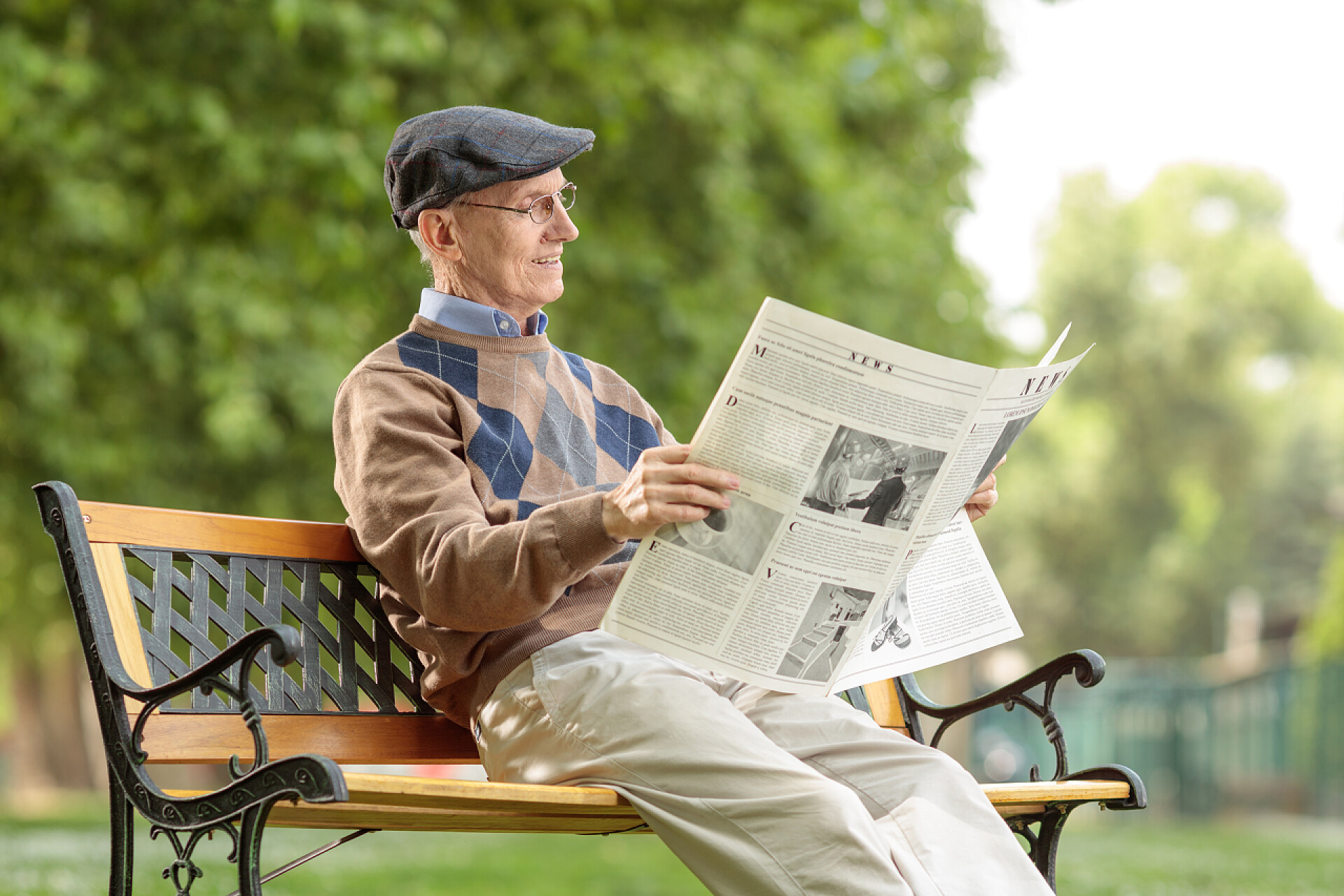 老人在公园里看报纸老人在公园里看报纸在长椅上