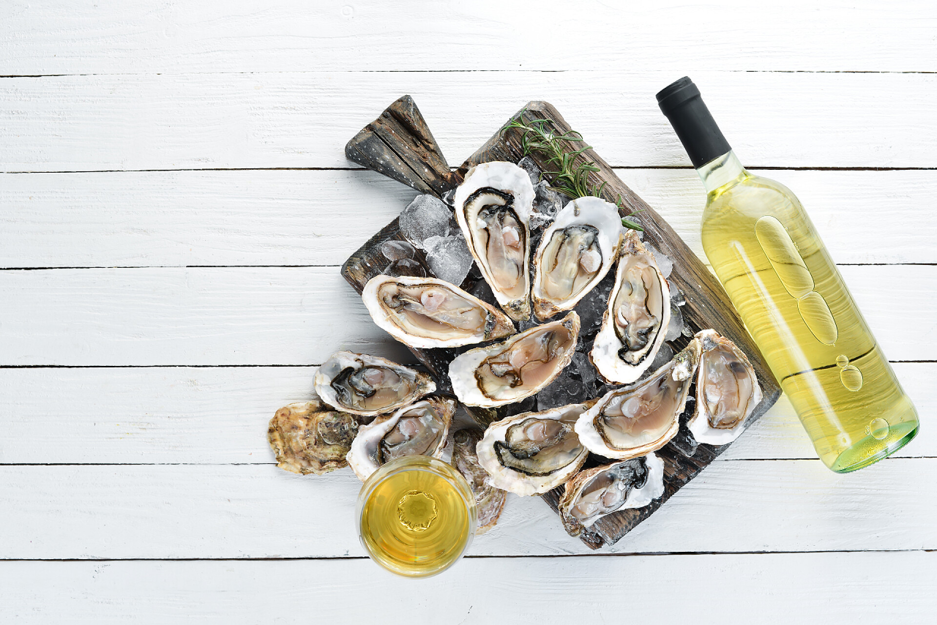 俯拍桌面上摆放的新鲜牡蛎和白葡萄酒新鲜的牡蛎配冰和白葡萄酒。海鲜。顶部视图。可用的复制空间.