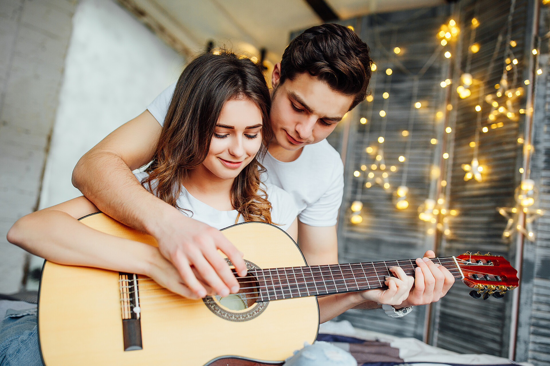 英俊的年轻人教女人在家里弹吉他英俊的年轻人教女人在家里弹吉他 