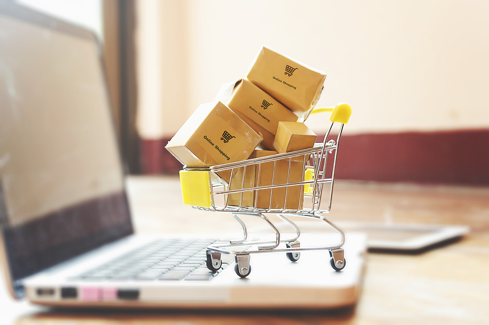 笔记本电脑键盘上购物车里的盒子笔记本电脑键盘上手推车上的盒子。关于网上商店的想法