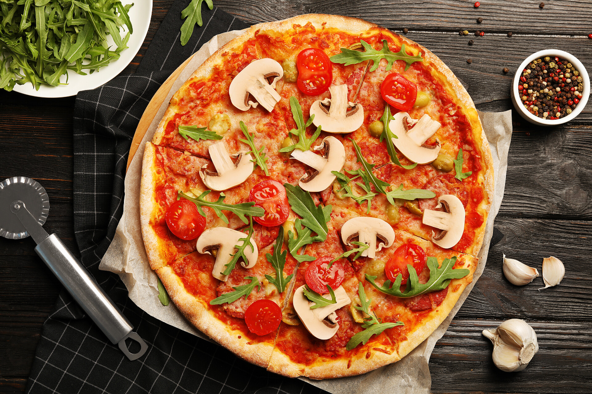 木质桌面上的美味比萨平躺组合与美味的比萨饼烤在烤箱