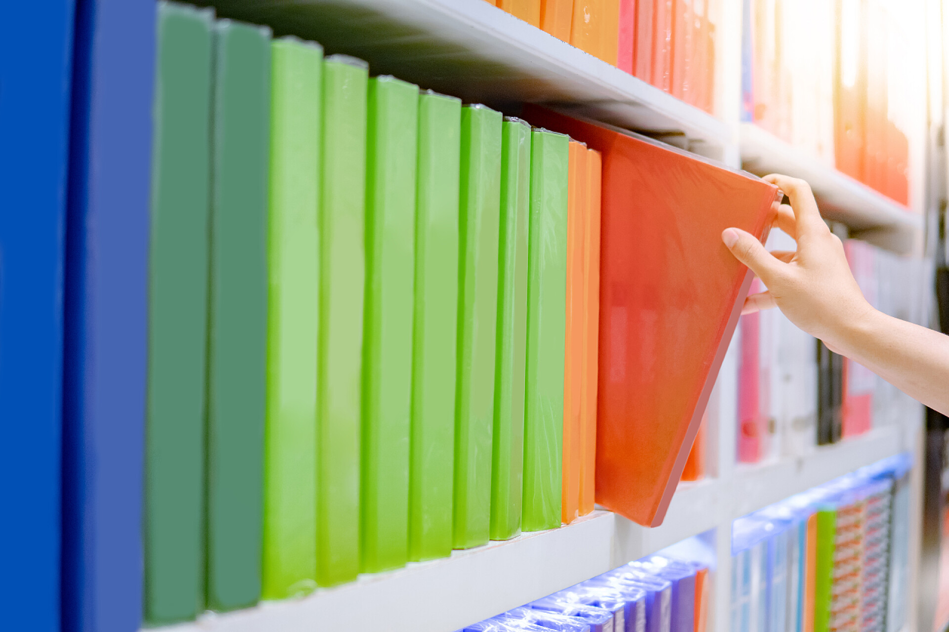 文具店货物架上的文件夹男性手选择文具店的文件夹