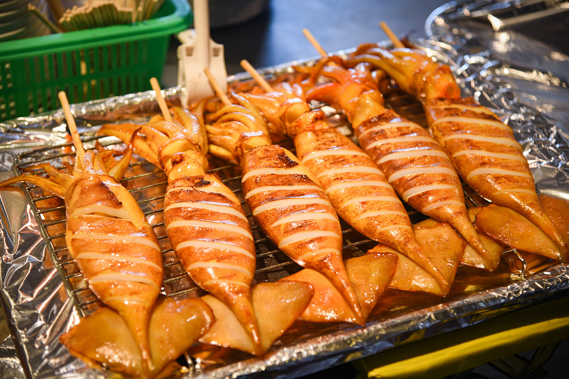 烤盘中的烤鱿鱼特写烤鱿鱼在烧烤与串棒在街头食品