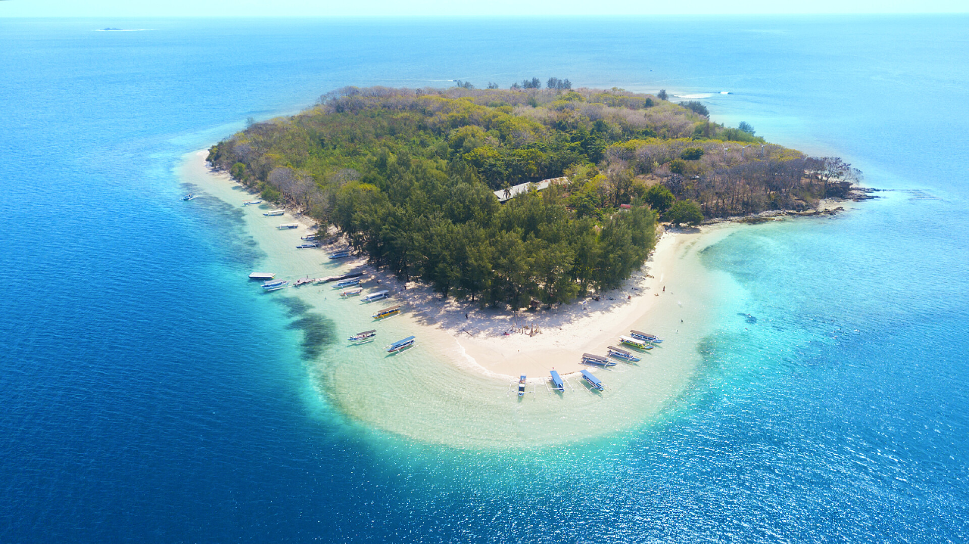 印度尼西亚海洋上岛屿的鸟瞰图停泊在吉利南古岛上的传统船只