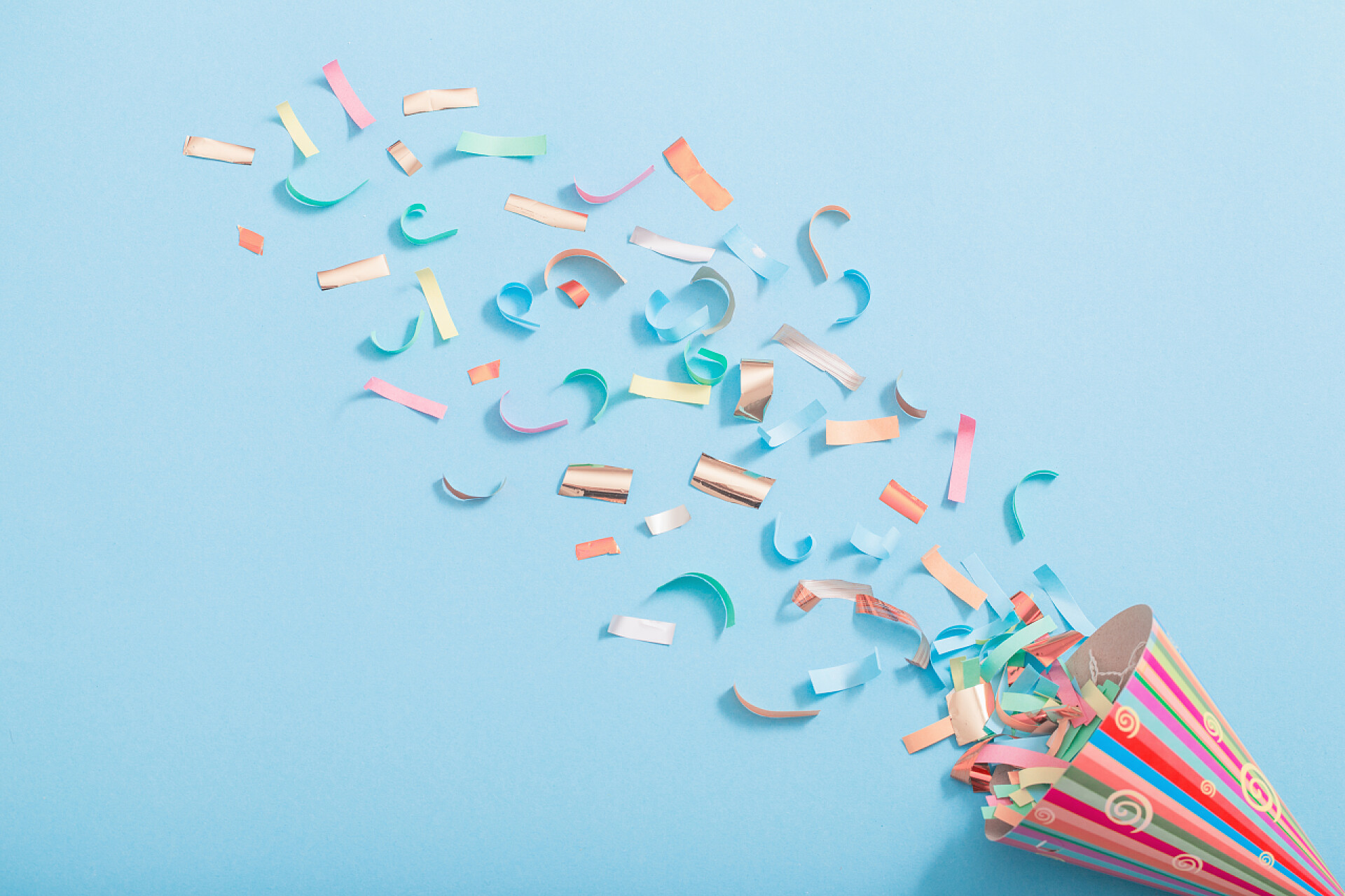 蓝色纸张上的生日聚会帽纸背上有纸屑的生日帽