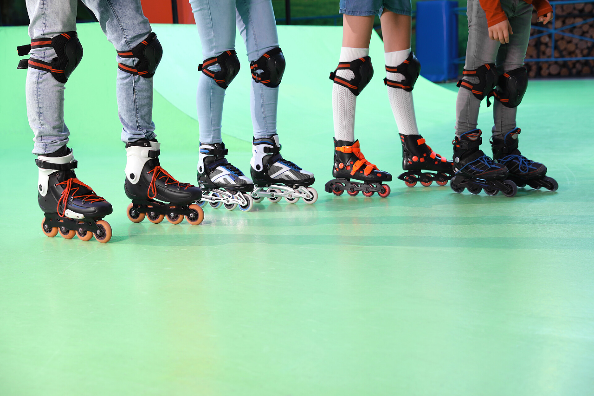 碧绿溜冰场上的四双溜冰鞋家庭花时间在轮滑溜冰场,特写