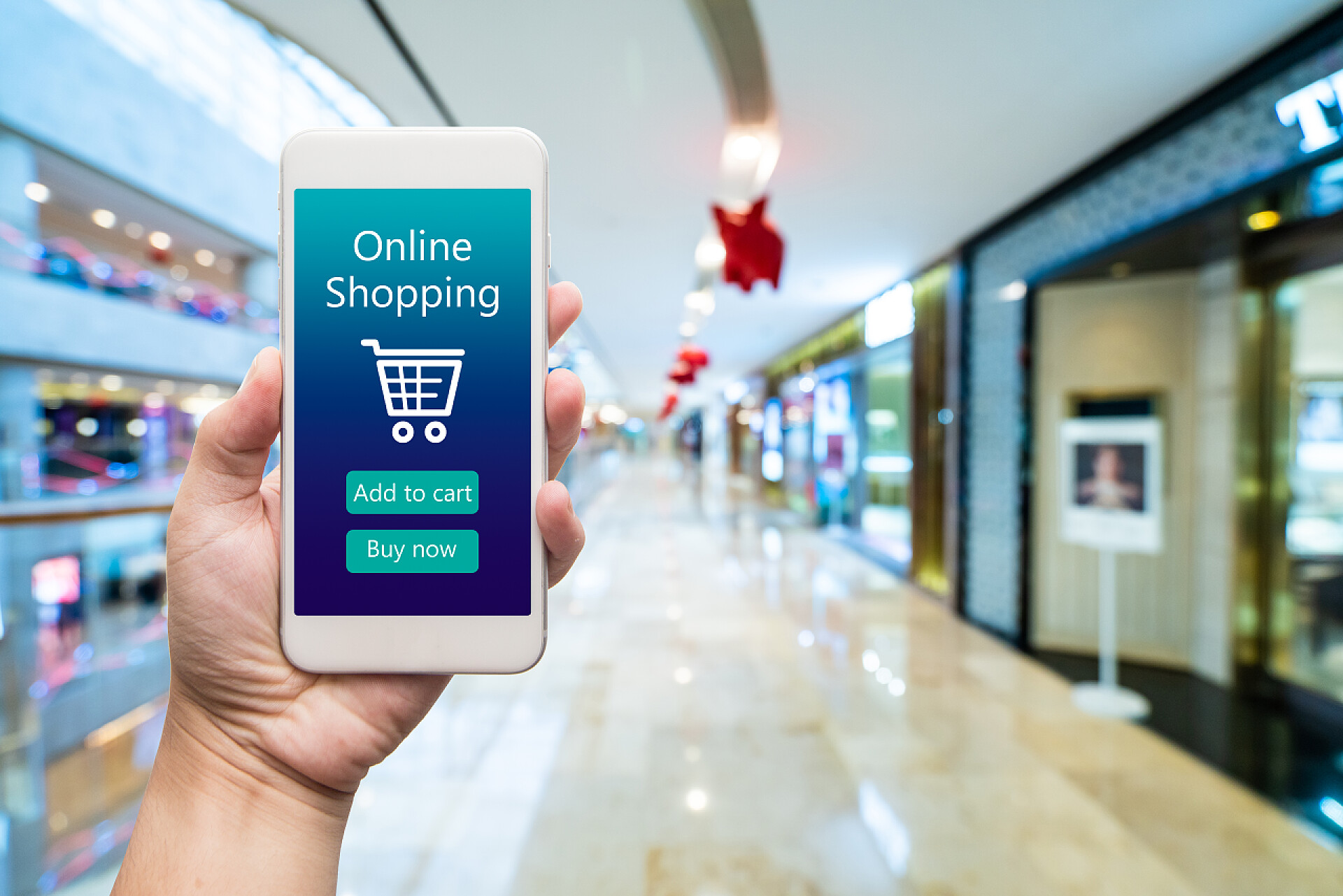 在商场中使用在线购物智能手机在线购物的女人手里。购物中心在坝