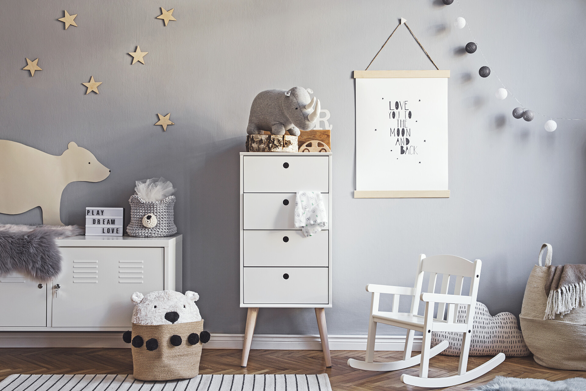 在白色的公主房斯堪的纳维亚苗圃，灰色墙壁上有模拟海报框架，白色家具，天然泰迪熊和玩具。可爱的现代内部游戏室与白色墙壁，婴儿配件和玩具.