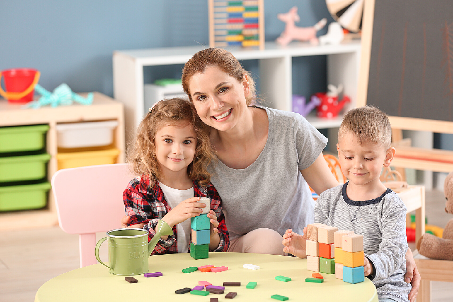 在玩积木的小孩子和老师幼儿园老师与可爱的小孩在幼儿园