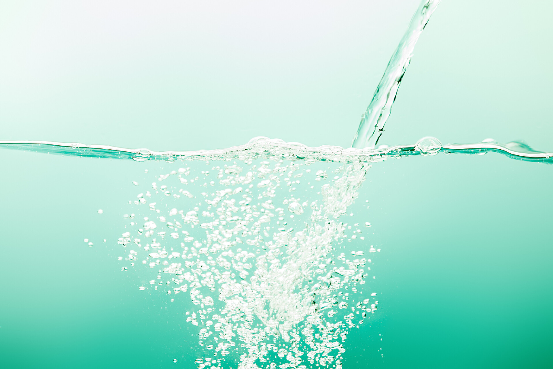 绿色背景上水和空气泡沫透明纯净水，绿色背景上有溪流和气泡