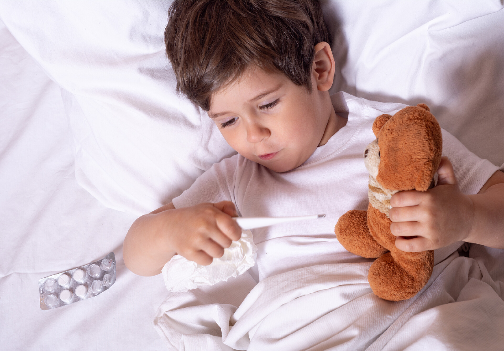 儿童流感治疗患病儿童发烧和生病在床上检查体温与温度计。儿童流感治疗.