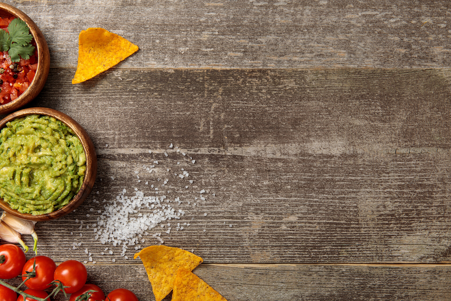 陶瓷碗里的各种调料墨西哥纳乔斯的顶视图服务与瓜卡莫莱和萨尔萨风化木桌上