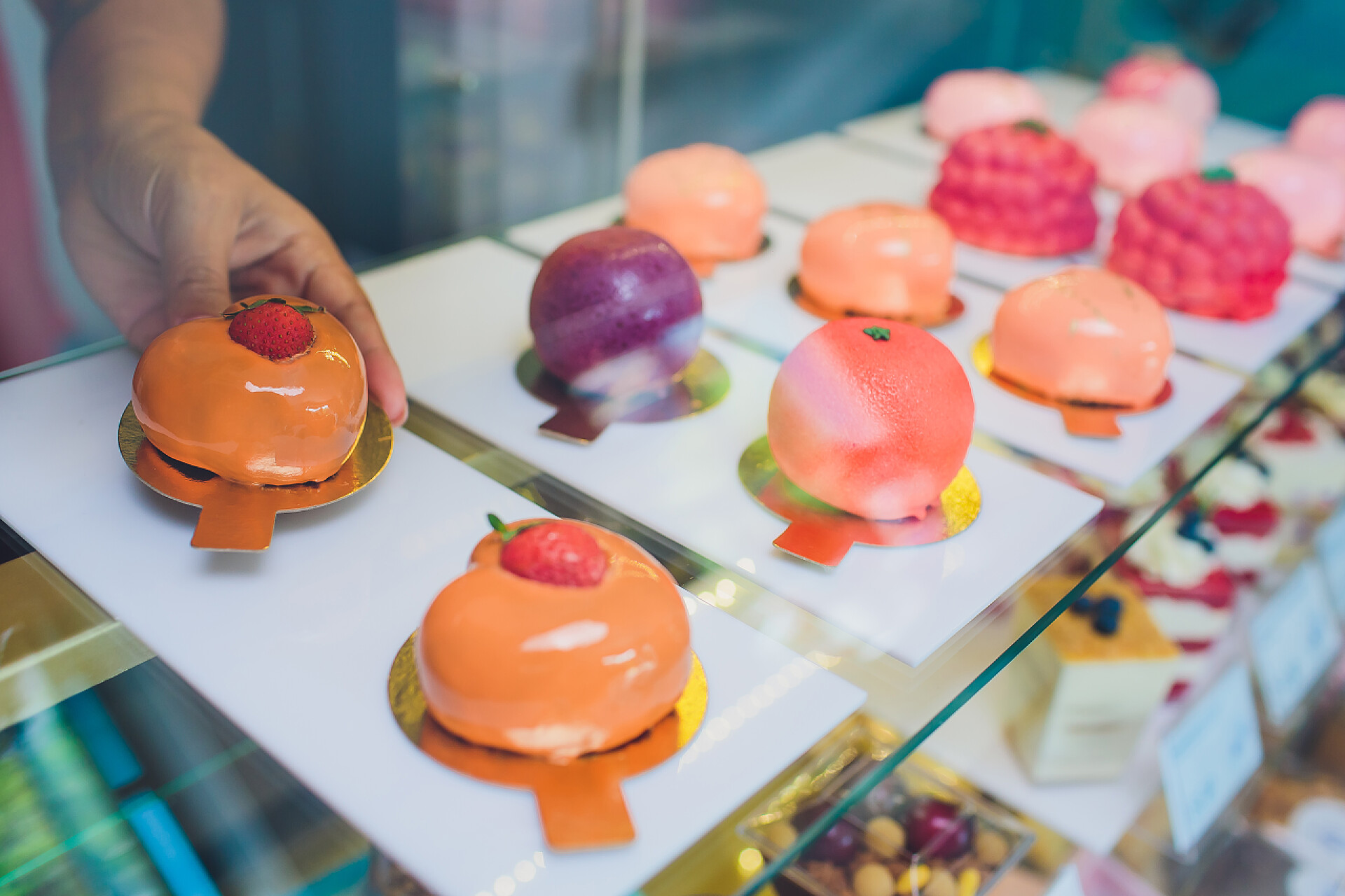 自助餐桌上甜点特写供应商手从面包店的橱窗里拿出蛋糕的特写.