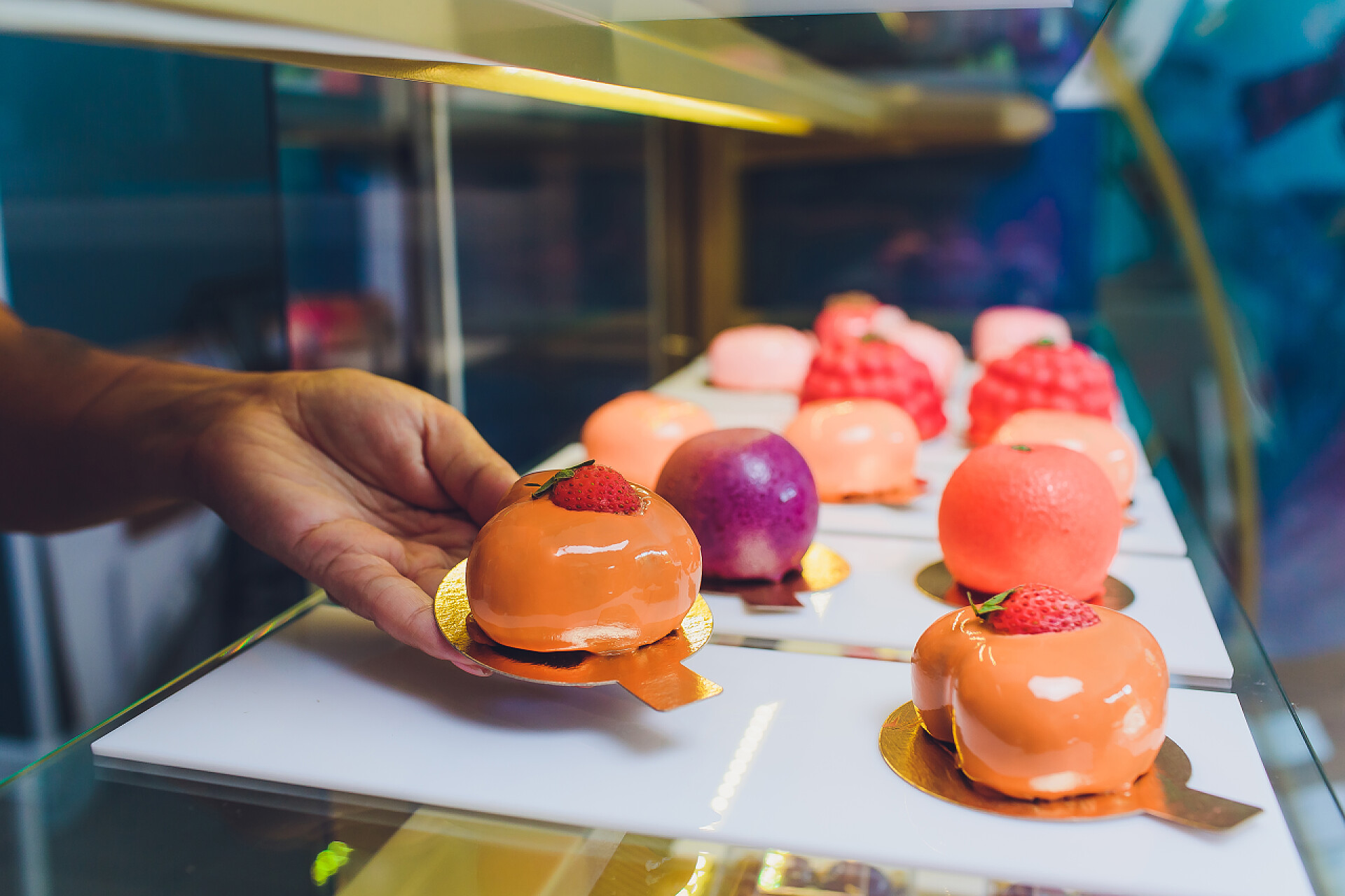 自助餐桌上甜点特写供应商手从面包店的橱窗里拿出蛋糕的特写.