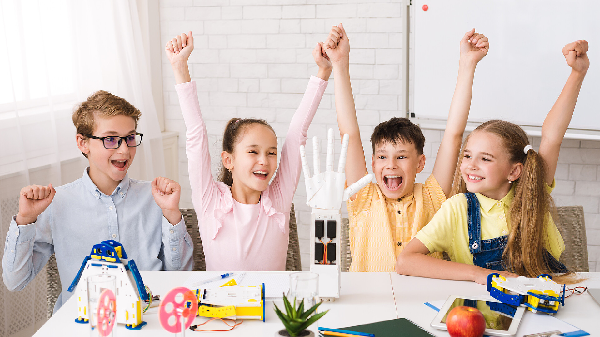 孩子在做机器手臂干教育。做机器人后举手的孩子