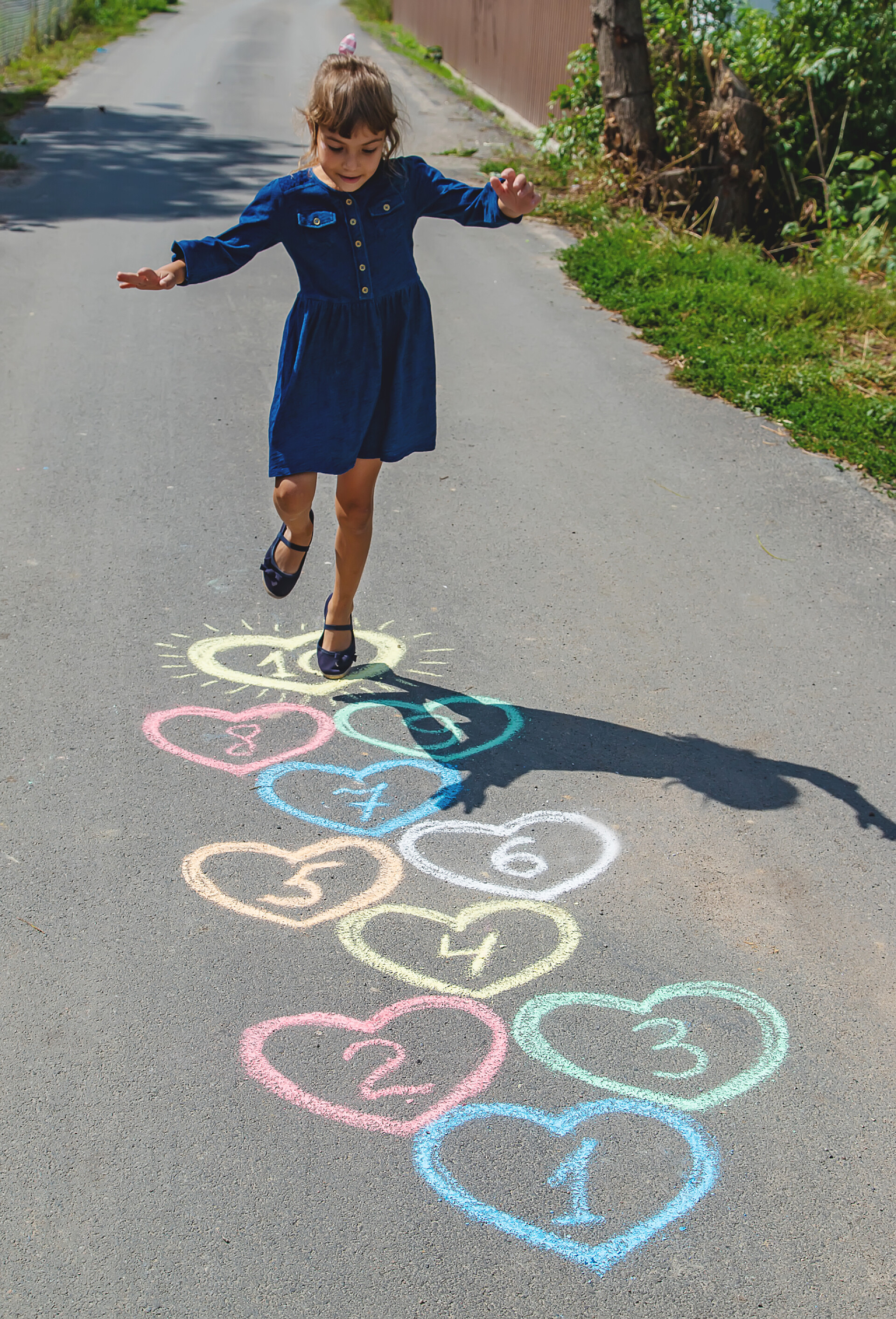 人行道上的儿童玩游戏人行道上的儿童跳高游戏。选择性聚焦.