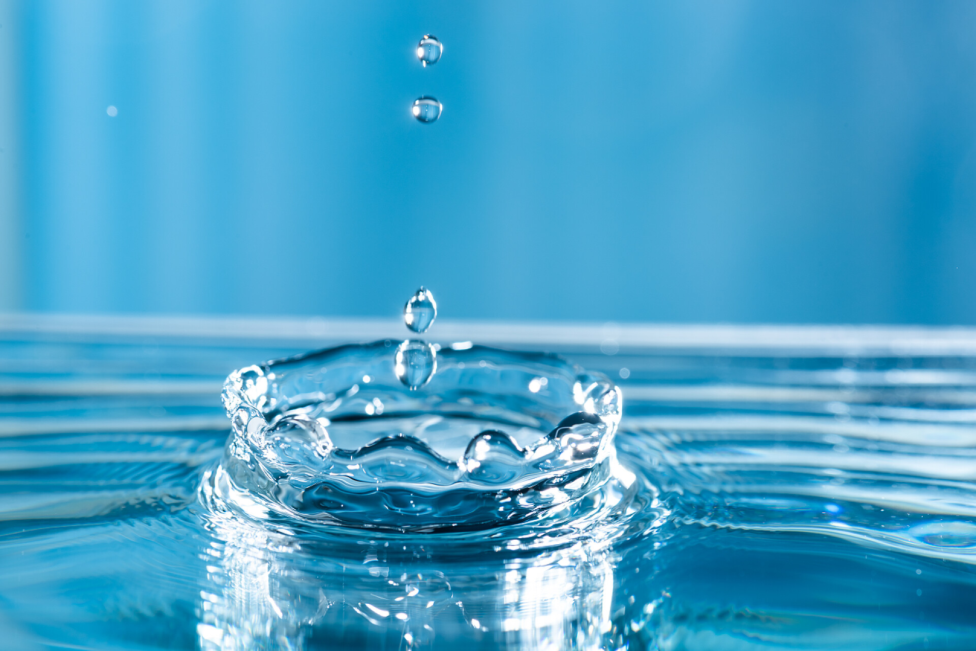 蓝色背景上的水滴泼水 