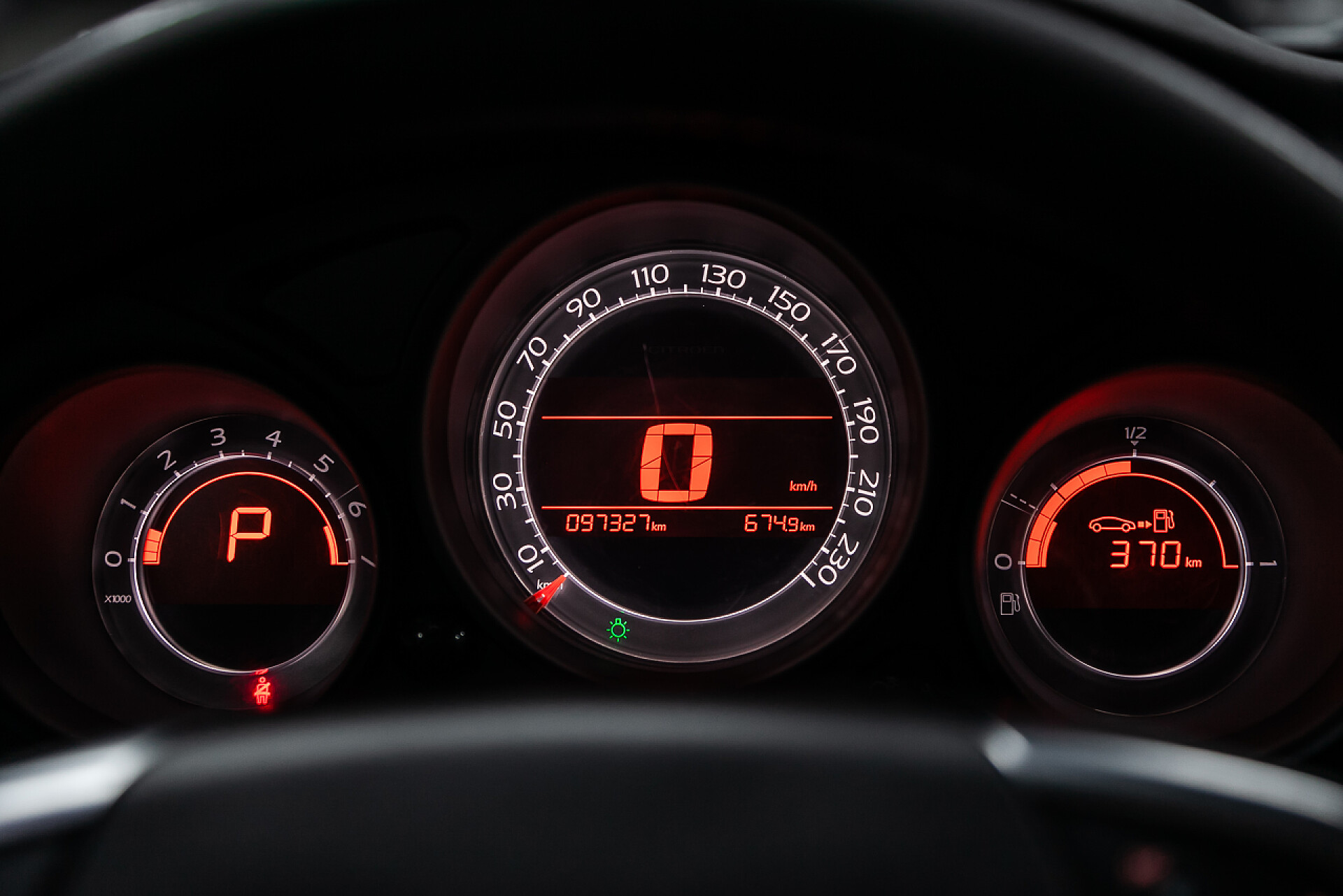 汽车里的仪表盘特写圆形仪表盘、速度计和带白色背光的速度计的特写。现代汽车中间点