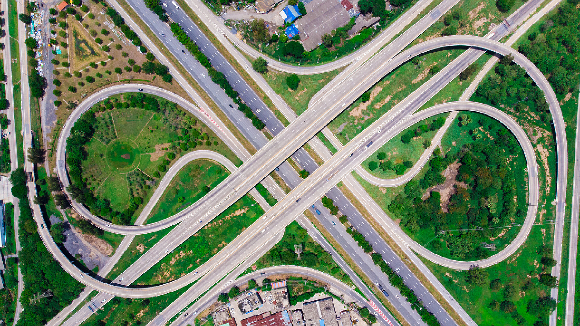 从上往下看的草坪和蜿蜒的马路城市交通交叉路口沥青路与汽车和卡车mo