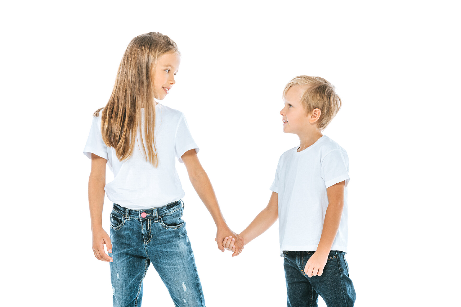 快乐的姐姐牵着弟弟快乐的姐姐和哥哥，穿着牛仔，手挽手，与白人隔离 