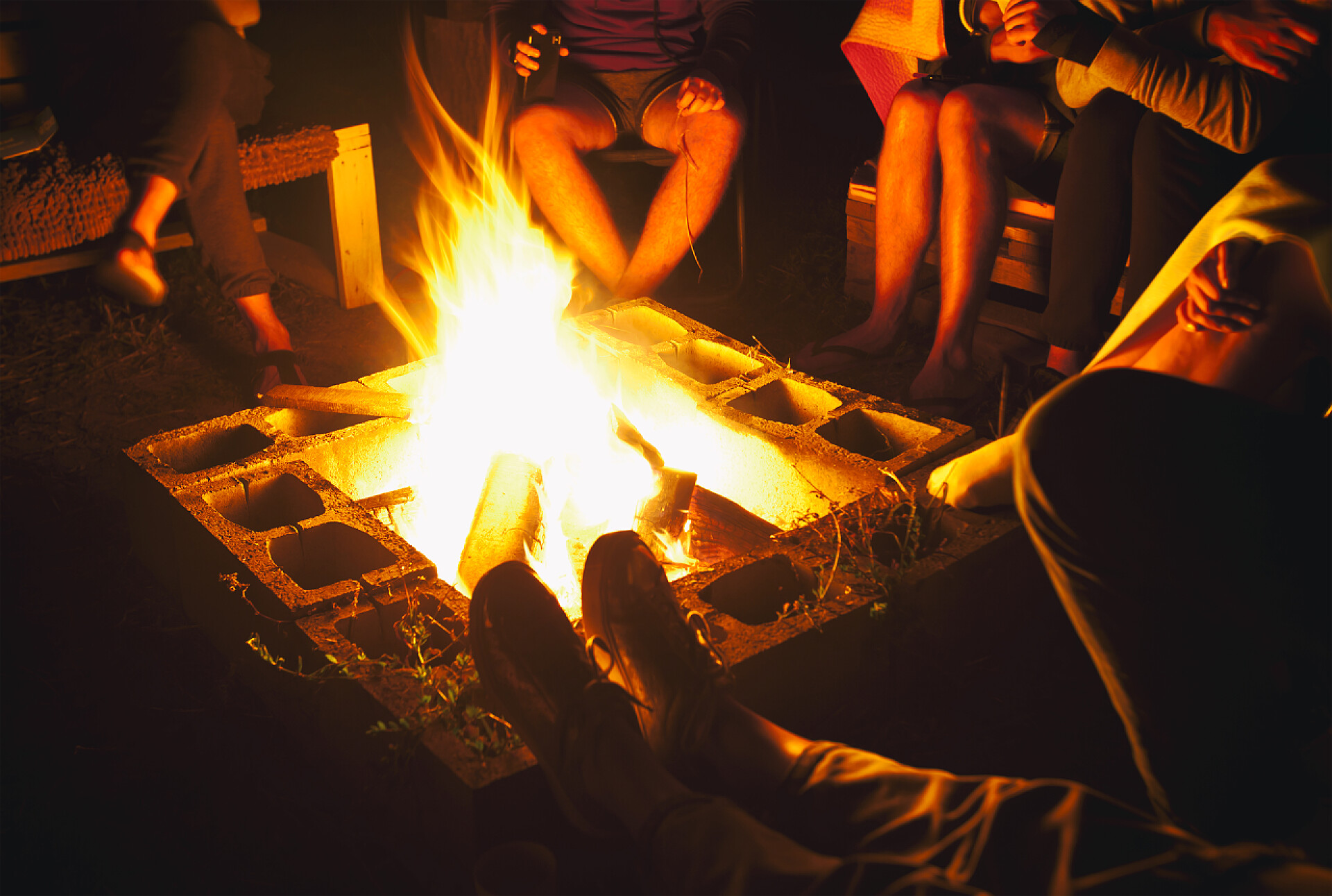 一群朋友坐在篝火旁一群朋友坐在篝火附近，在夜晚