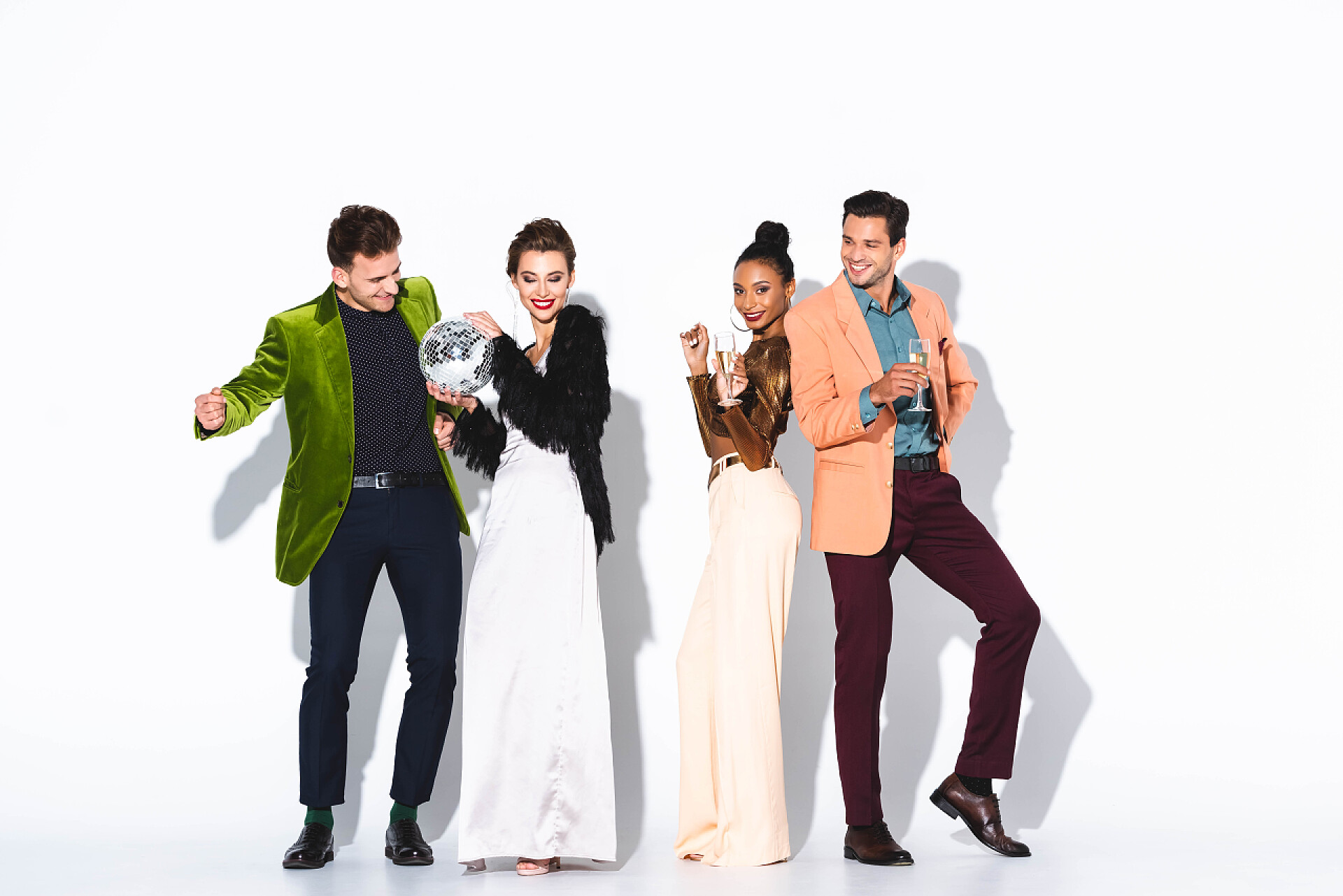 白色背景上一群年轻人在庆祝快乐而时尚的多文化朋友，拿着香槟酒杯，在白色的迪斯科舞会上 