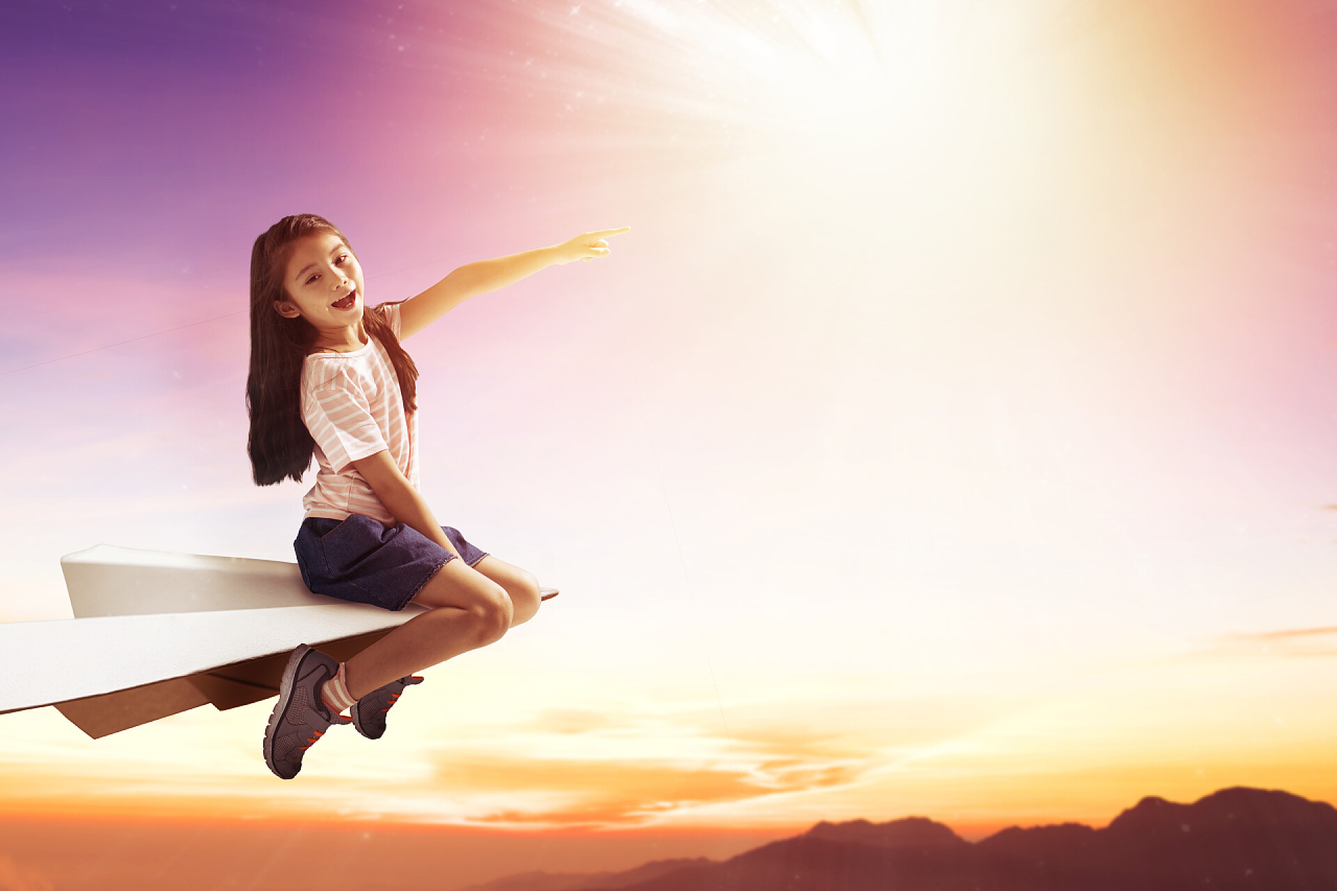 快乐的小女孩在纸飞机上飞翔快乐的小女孩在纸飞机上，在天空中飞翔