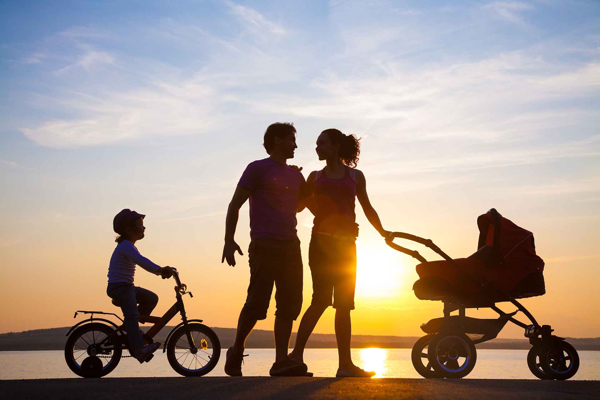 日落时分一家人在海边散步的剪影日落大道上散步的幸福家庭