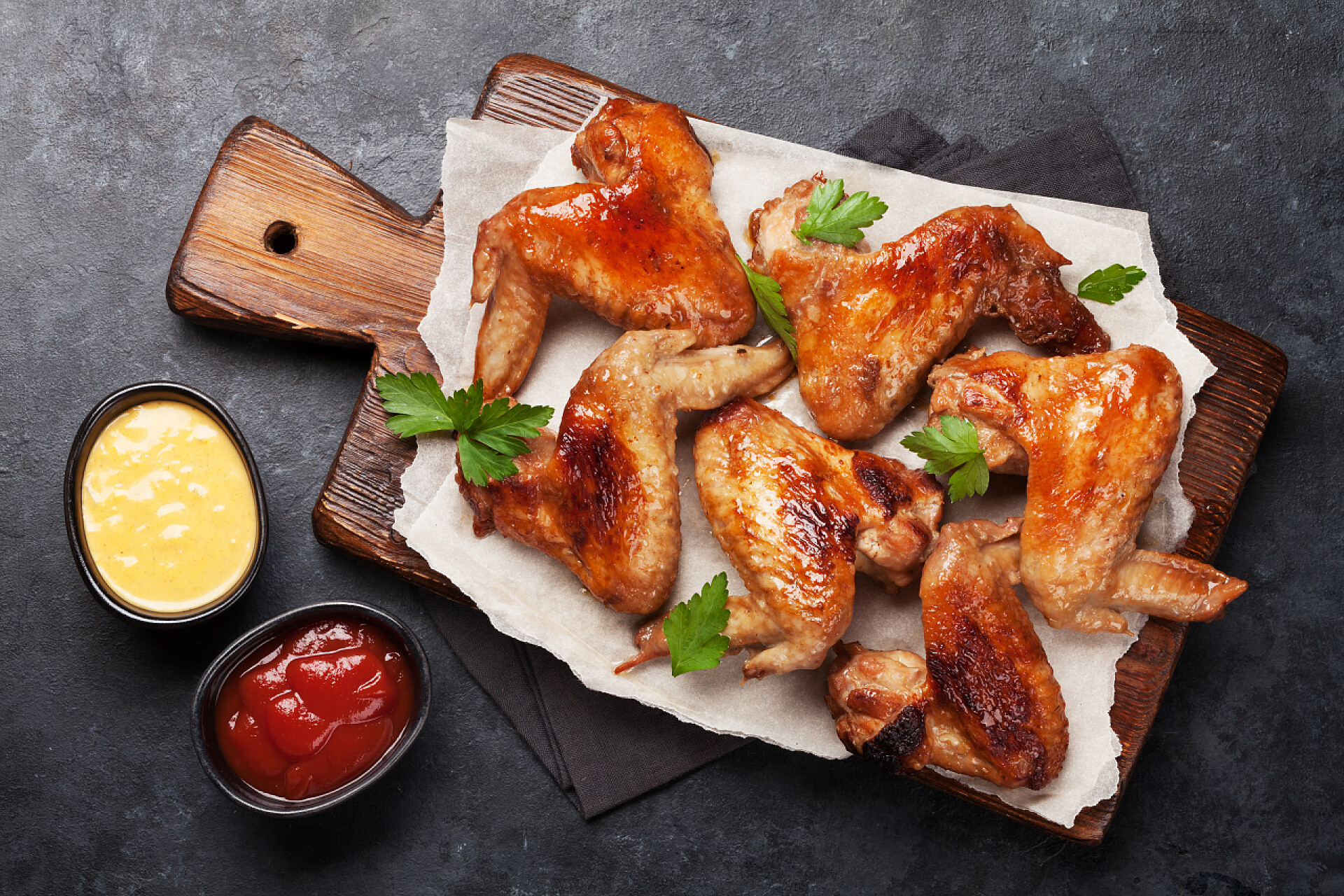 俯拍一份奥尔良烤翅热烤鸡肉鸡翅加酱汁.石桌上的顶视图