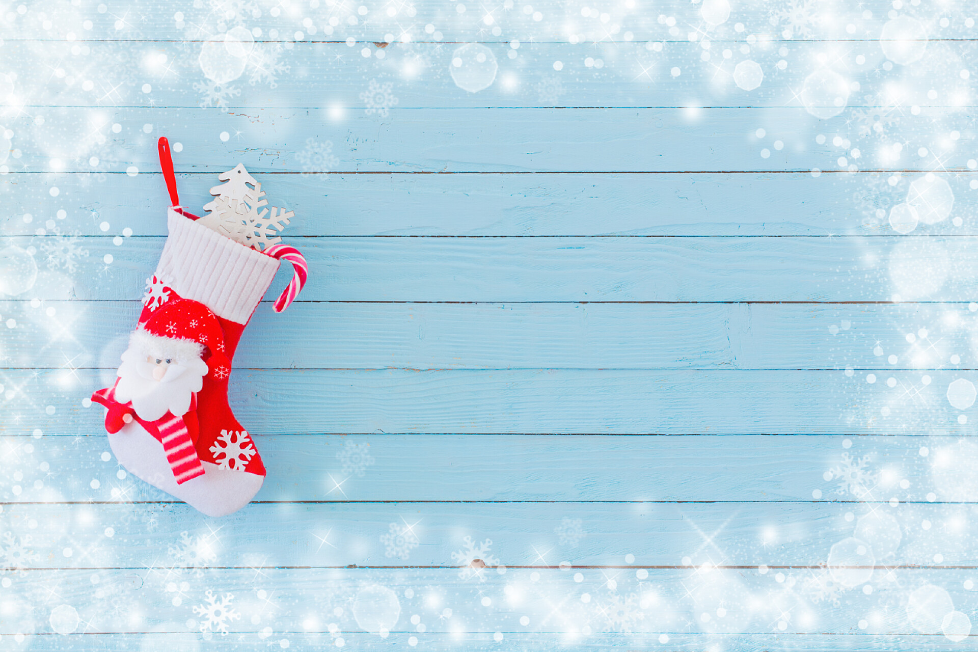 蓝色木制背景上挂着礼物的圣诞长袜蓝色木制背景上挂着礼物的圣诞长袜