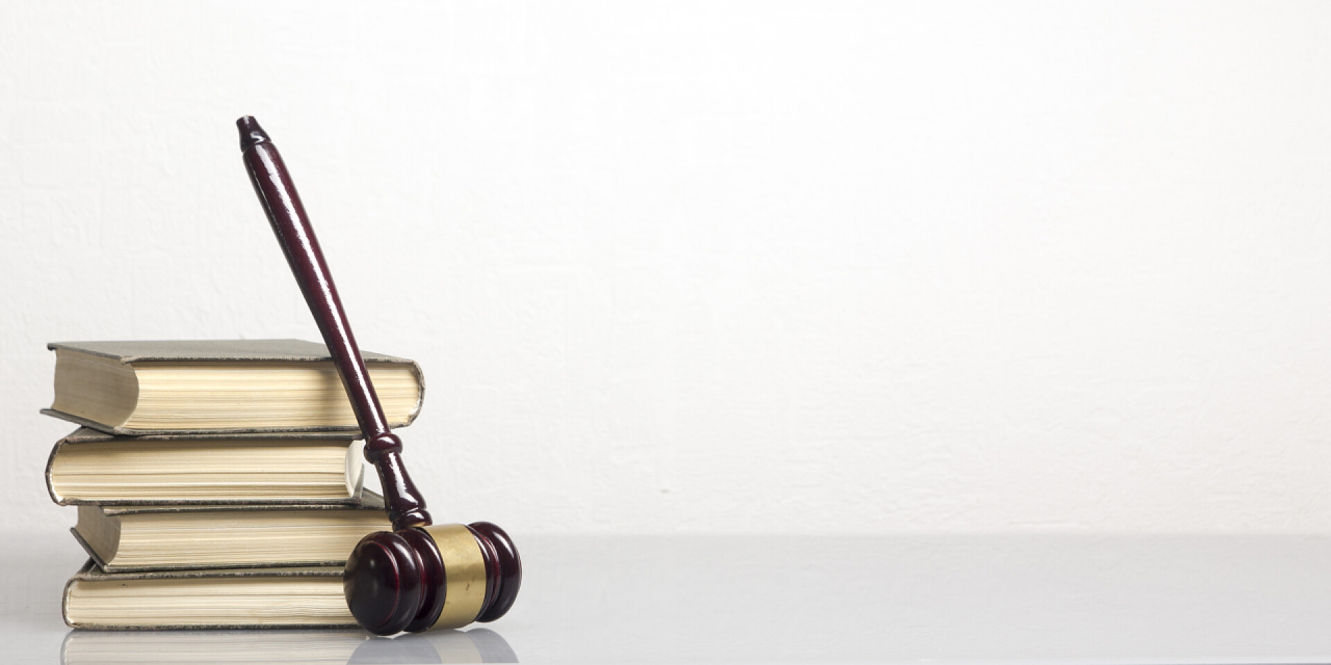 白色背景上靠着法律书籍的木槌