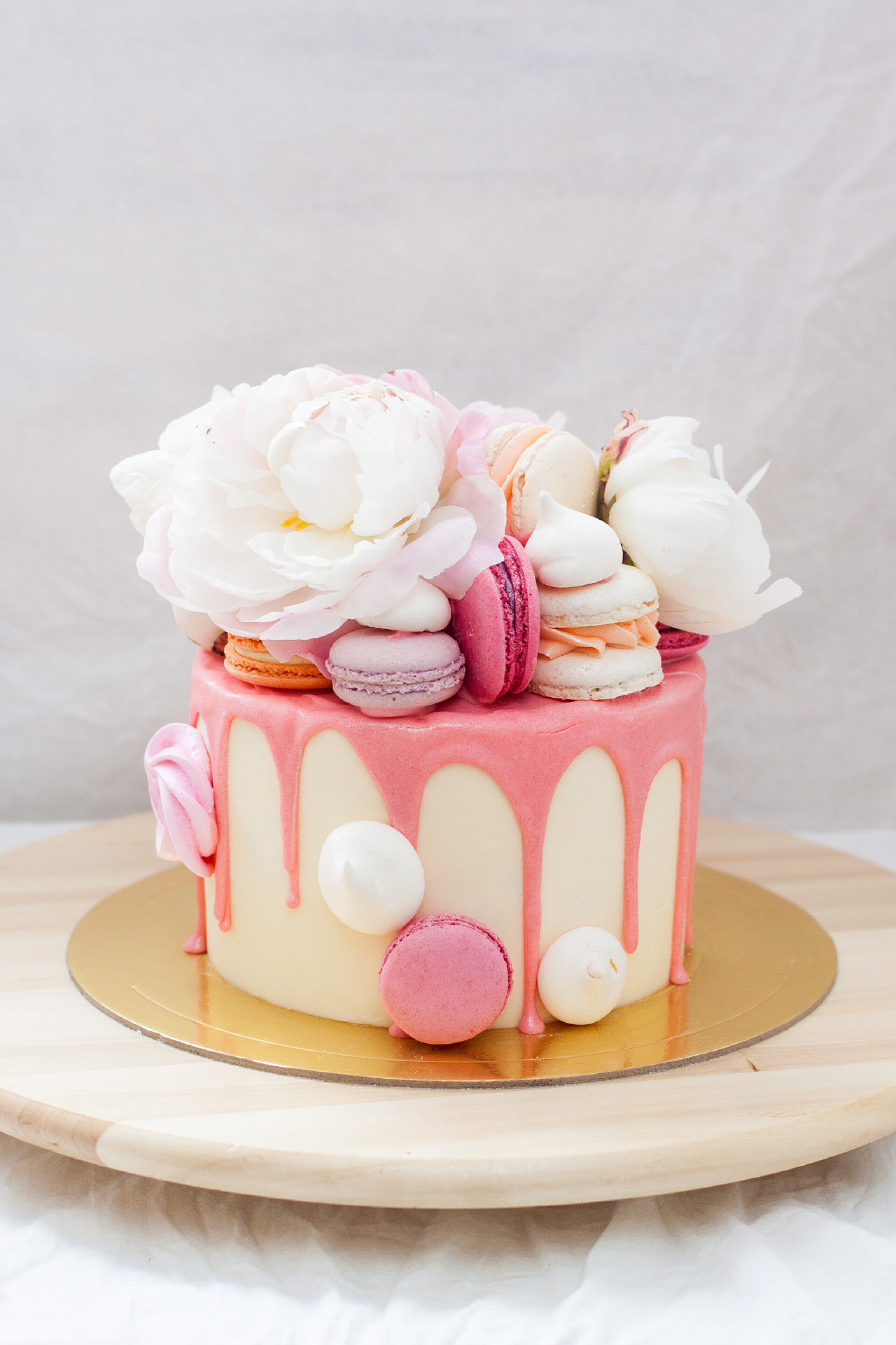 桌子上的鲜花蛋糕白饼，粉红融化的巧克力，新鲜的玫瑰和牡丹，金银花和蛋白糖. 