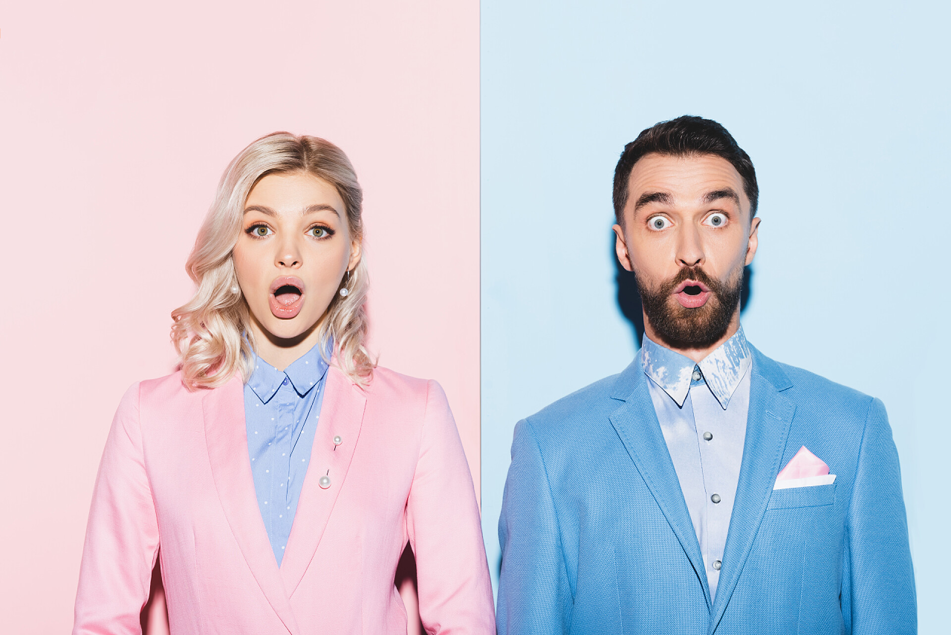 粉蓝背景中惊讶的男人和女人2.震惊的女人和英俊的男人用粉色和蓝色的背景看着摄像机 