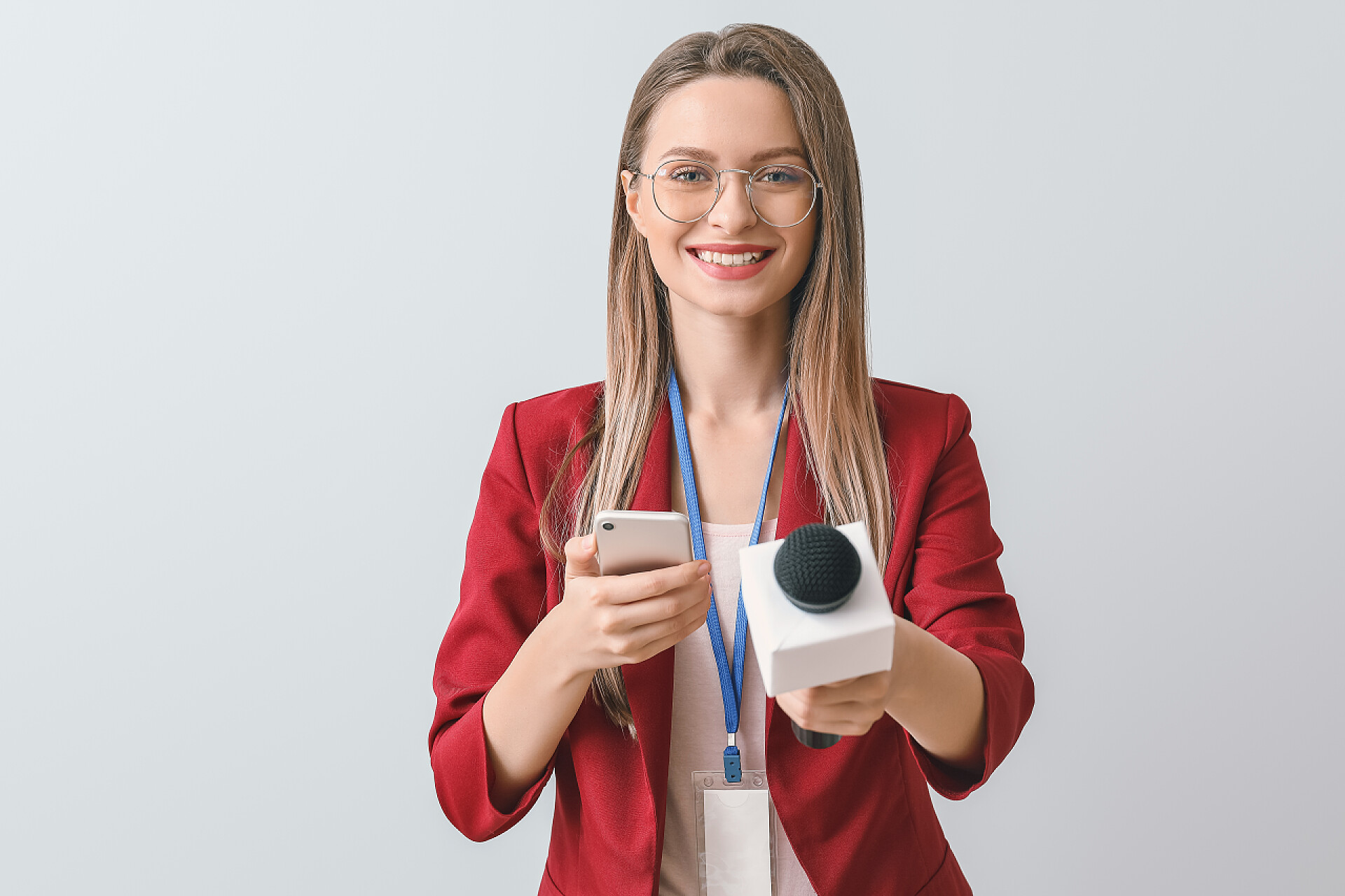 灰色背景中一个面带微笑的女记者背景浅的女记者