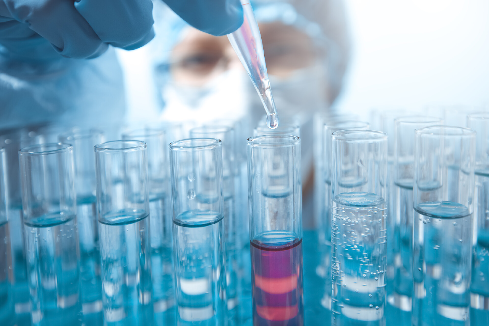 科学家正在实验室里进行试管研究科罗纳威斯疫苗一滴水滴从管道滴入试管.实验室研究.