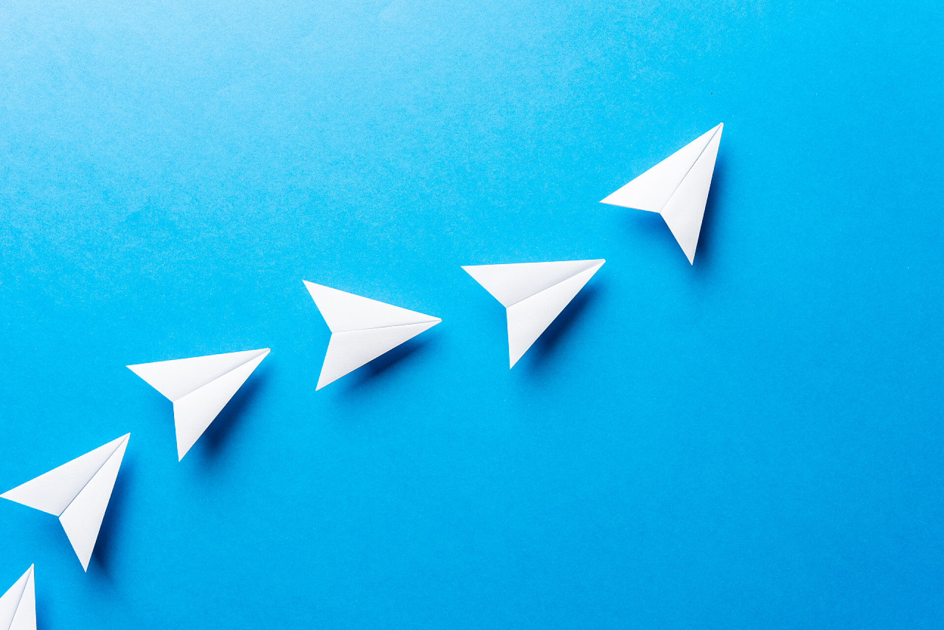 蓝色背景上的纸飞机进展概念。敏捷的发展成就、动力、成长