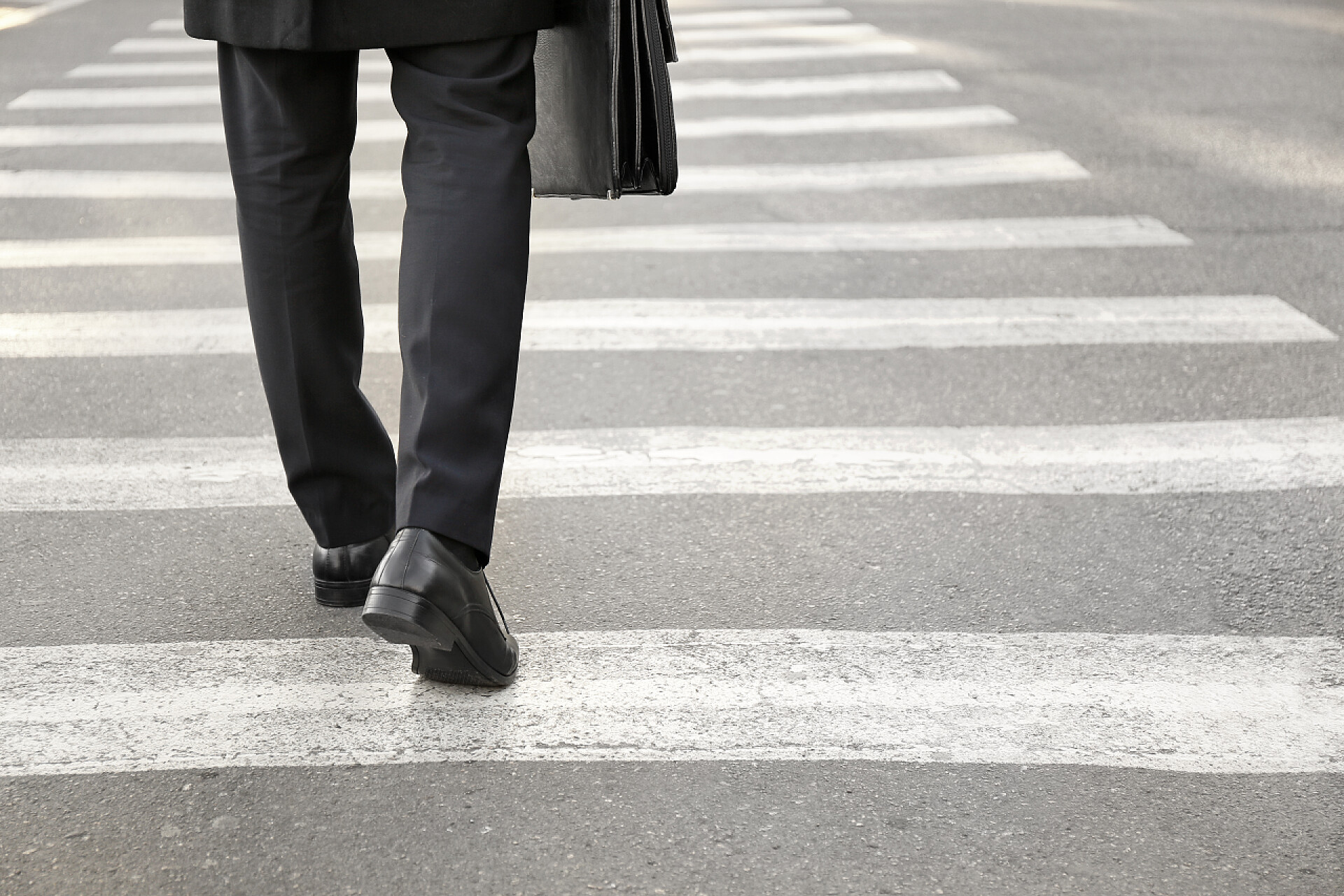 一个商务男人走在斑马线上Young businessman crossing road. Concept of choice
