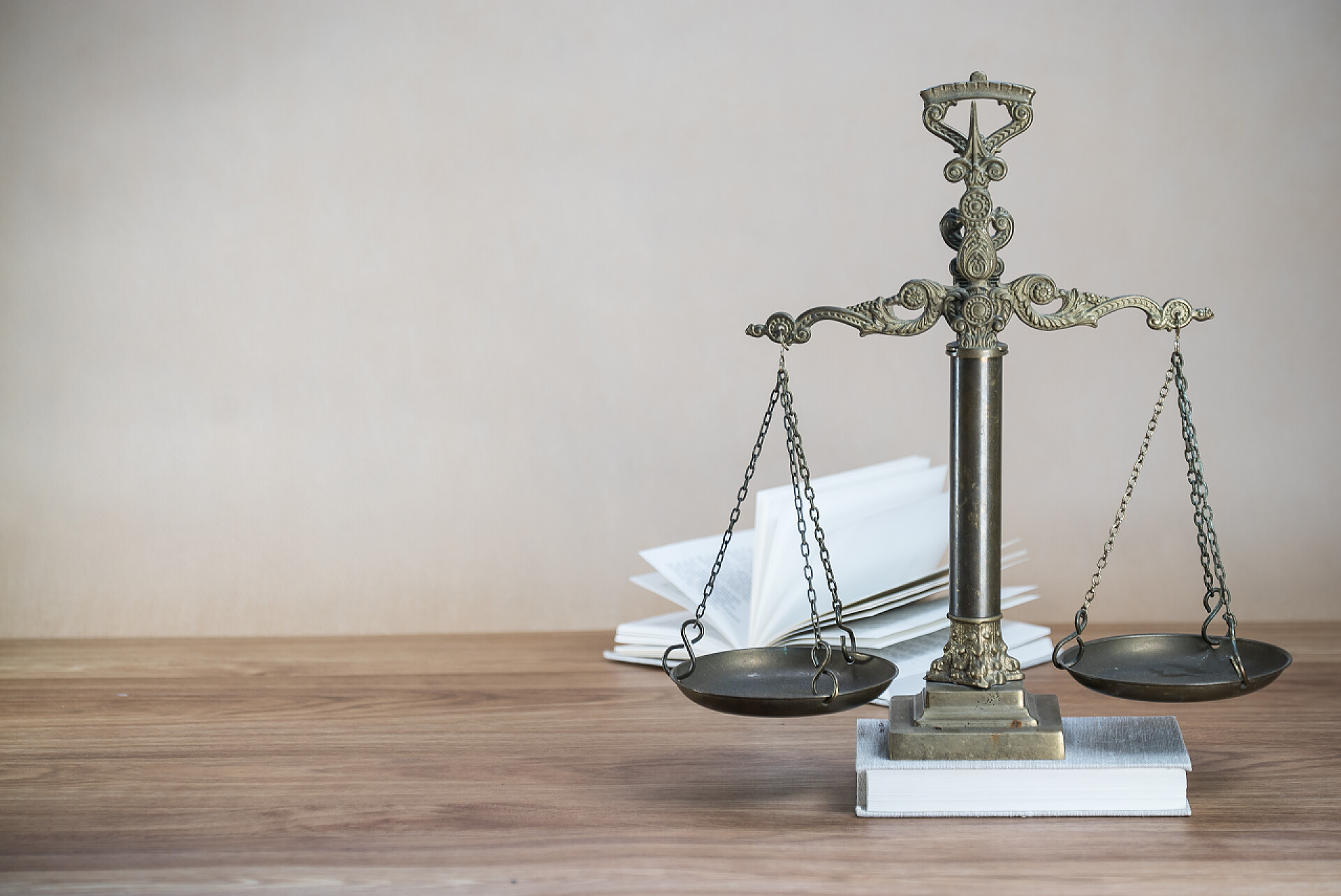桌子上的法律书籍天平木制桌子背景下的司法尺度