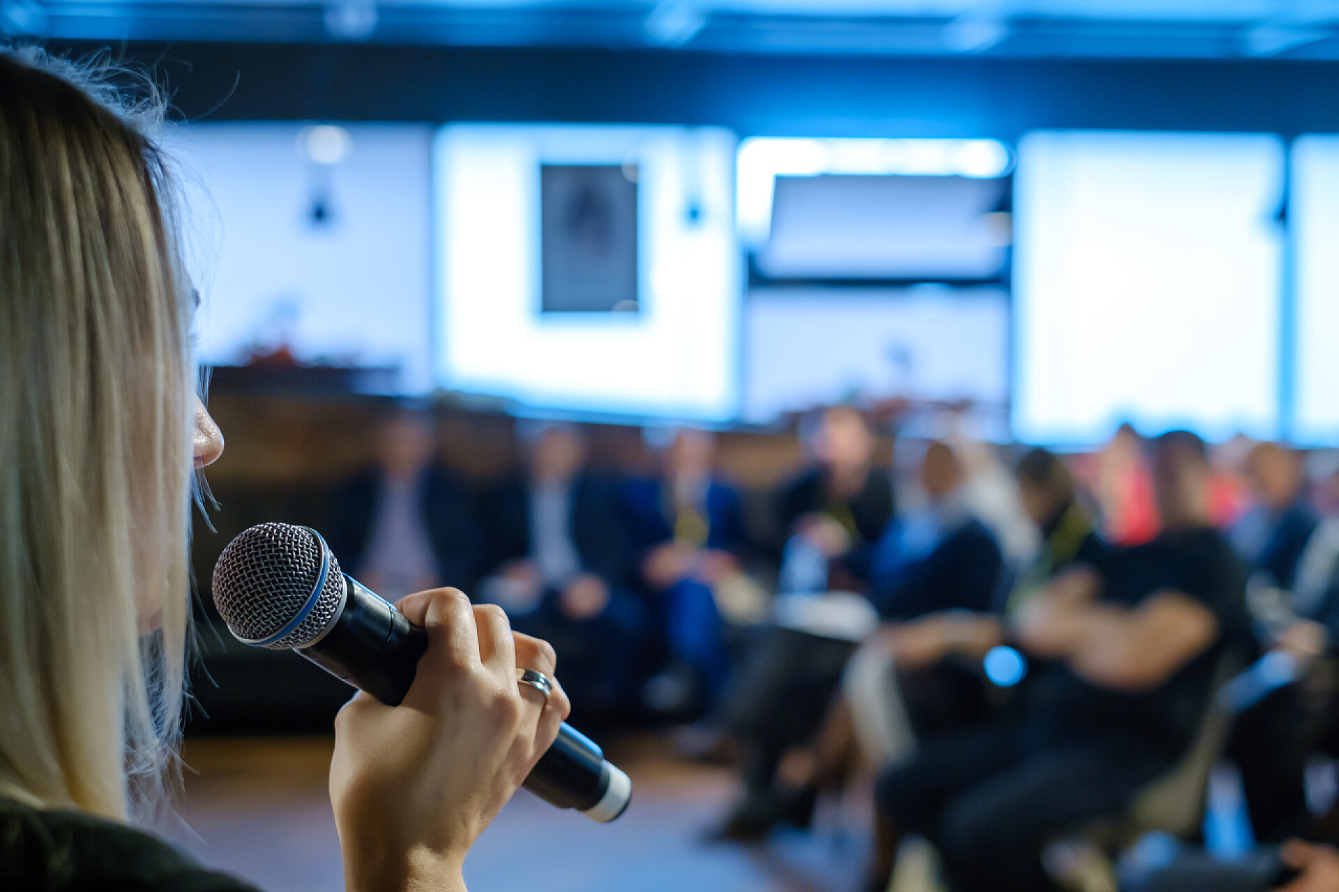 主持人拿着话筒在主持会议女主持人向观众讲话